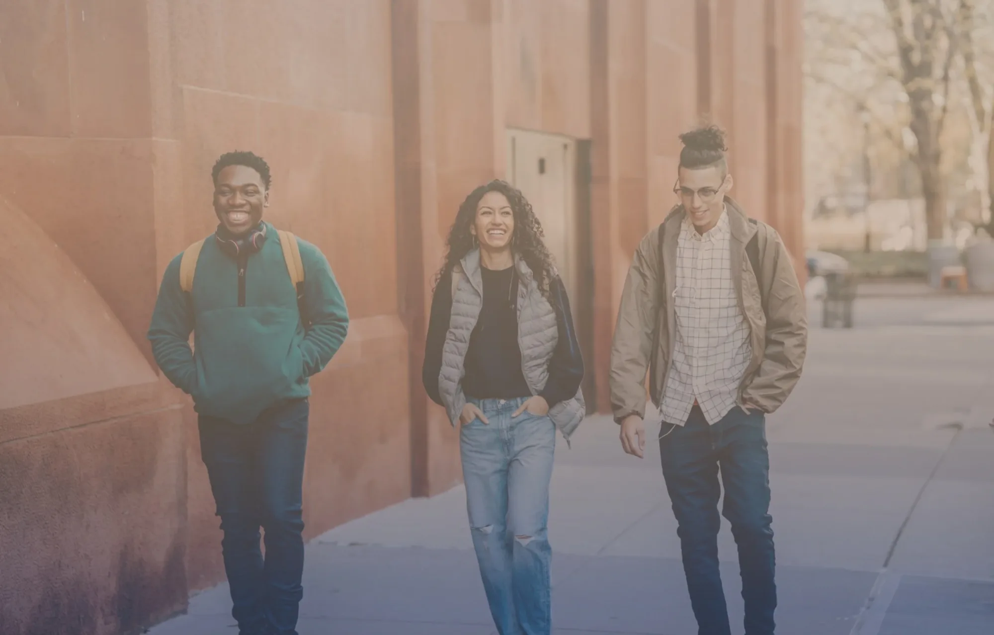 Three young adults walking together down a city street