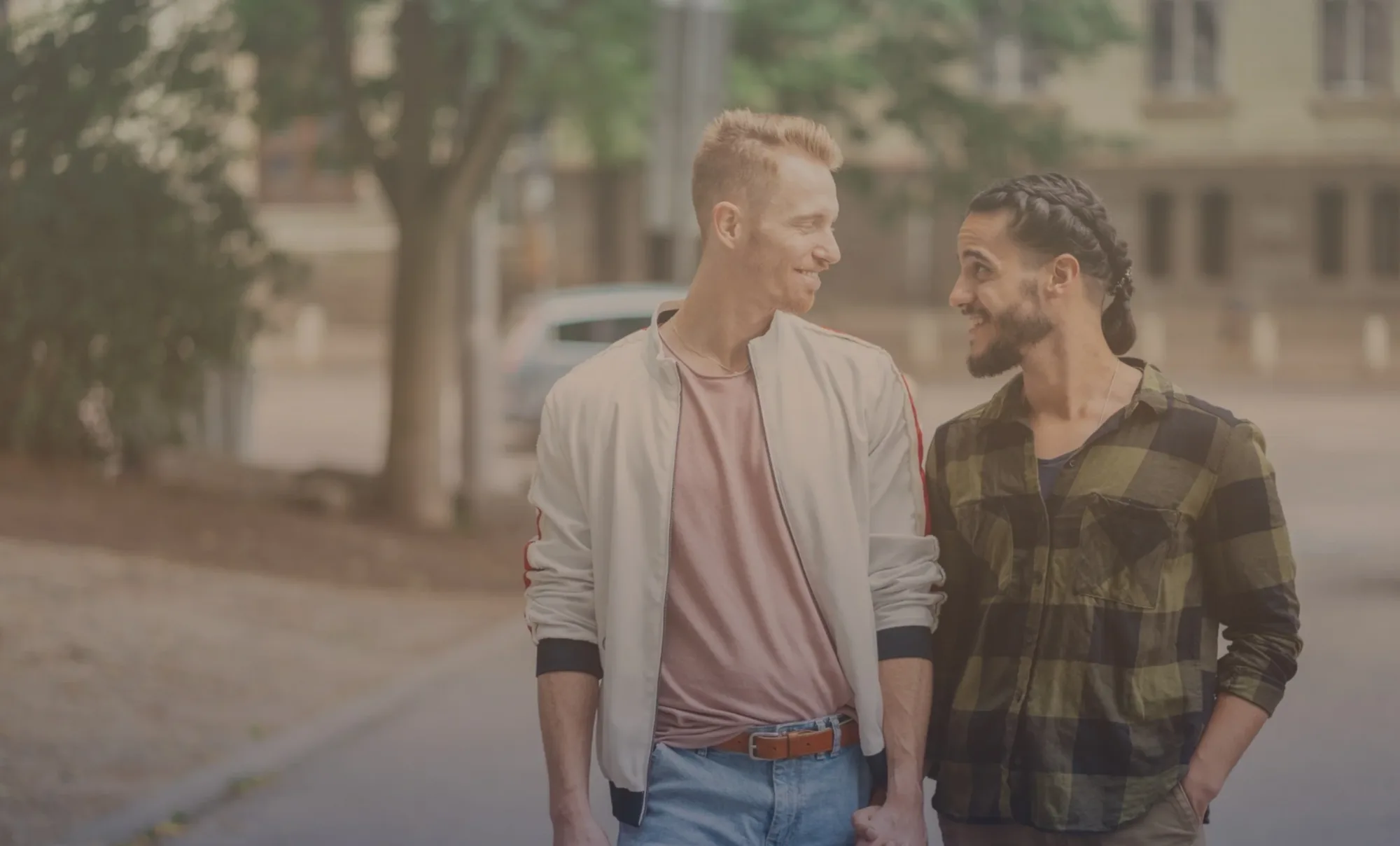 Two men walking side by side and talking on a city street