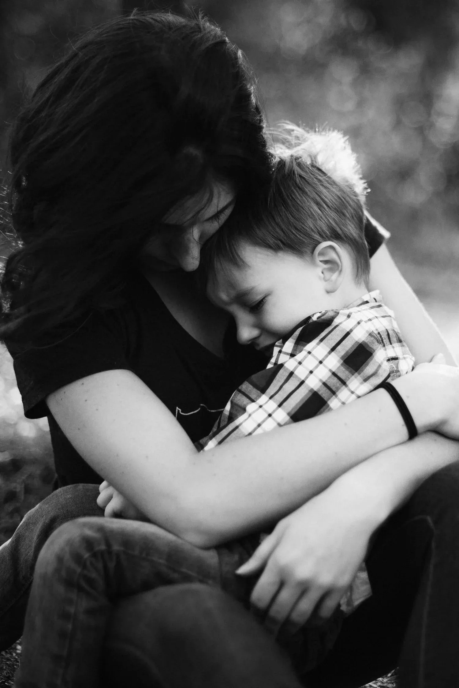 Black-and-white photo of a parent hugging a child tightly