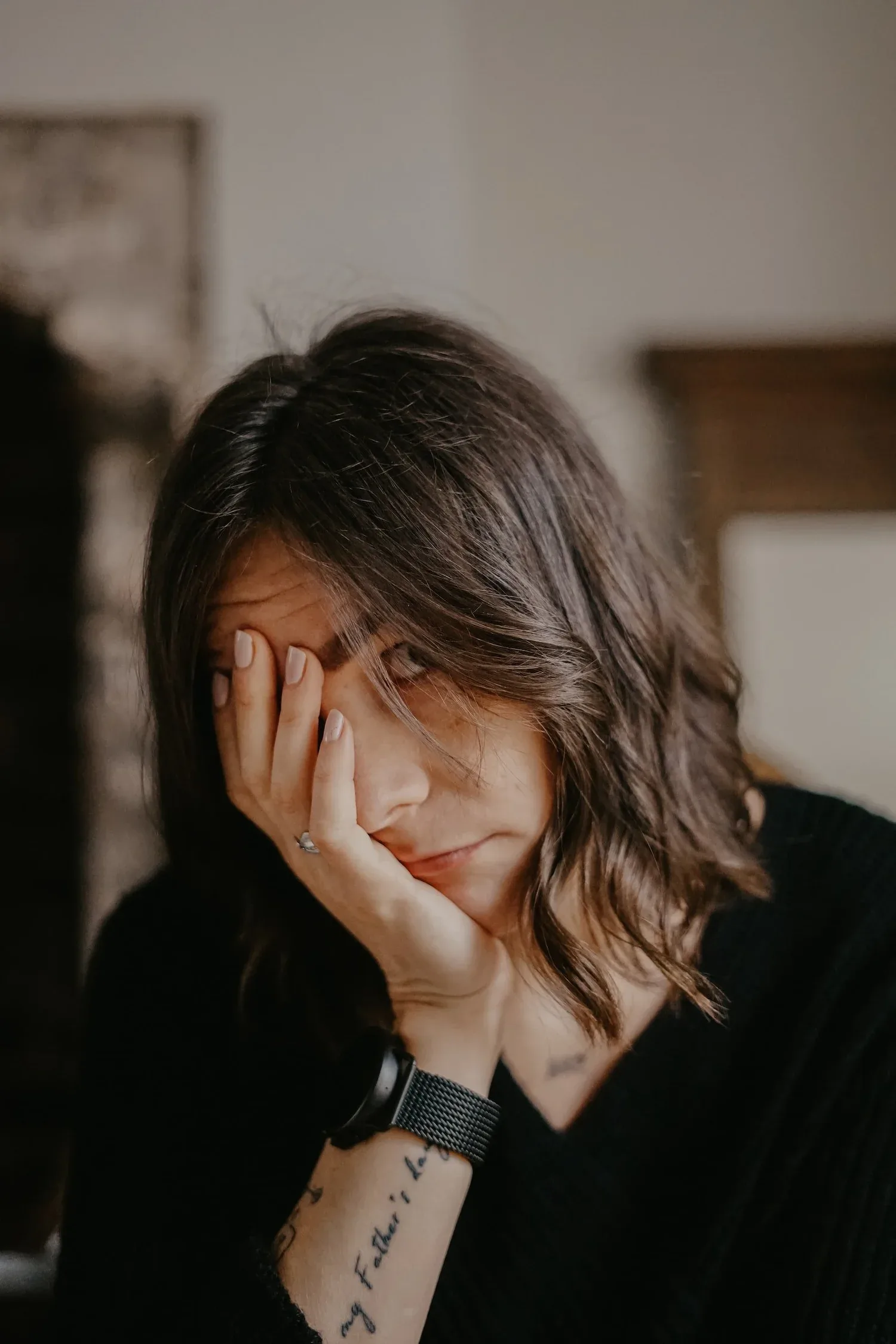 Young woman resting her cheek in her hand, smiling softly