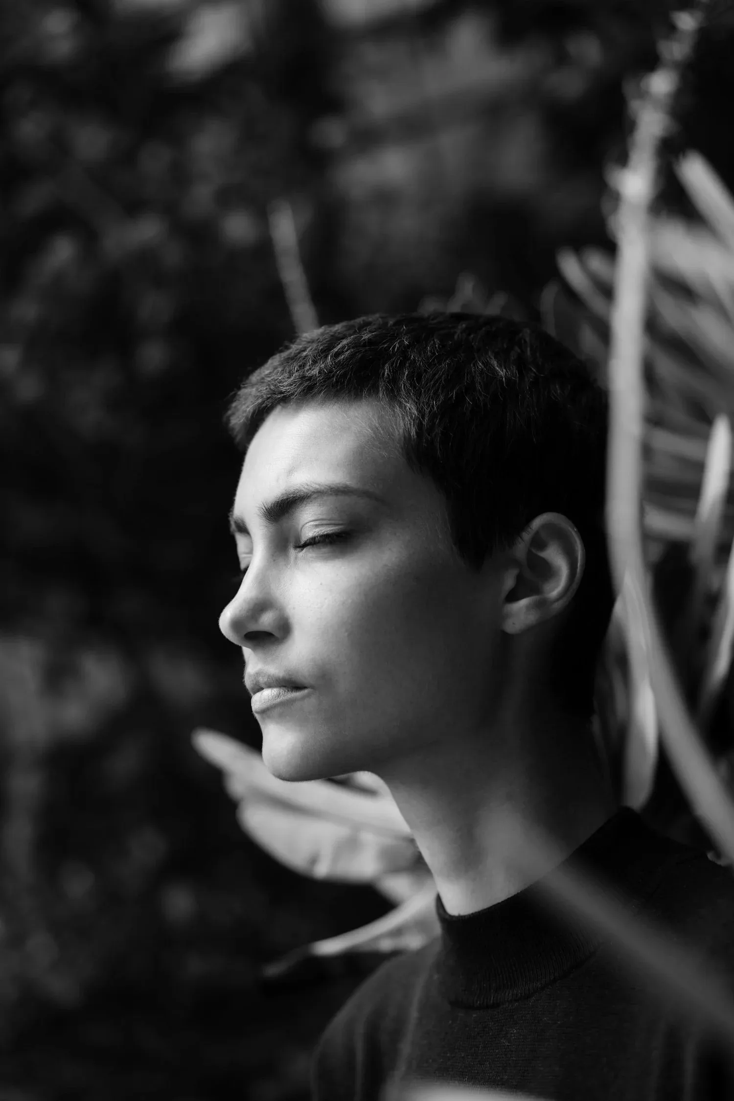 Black-and-white portrait of a person with short hair in profile