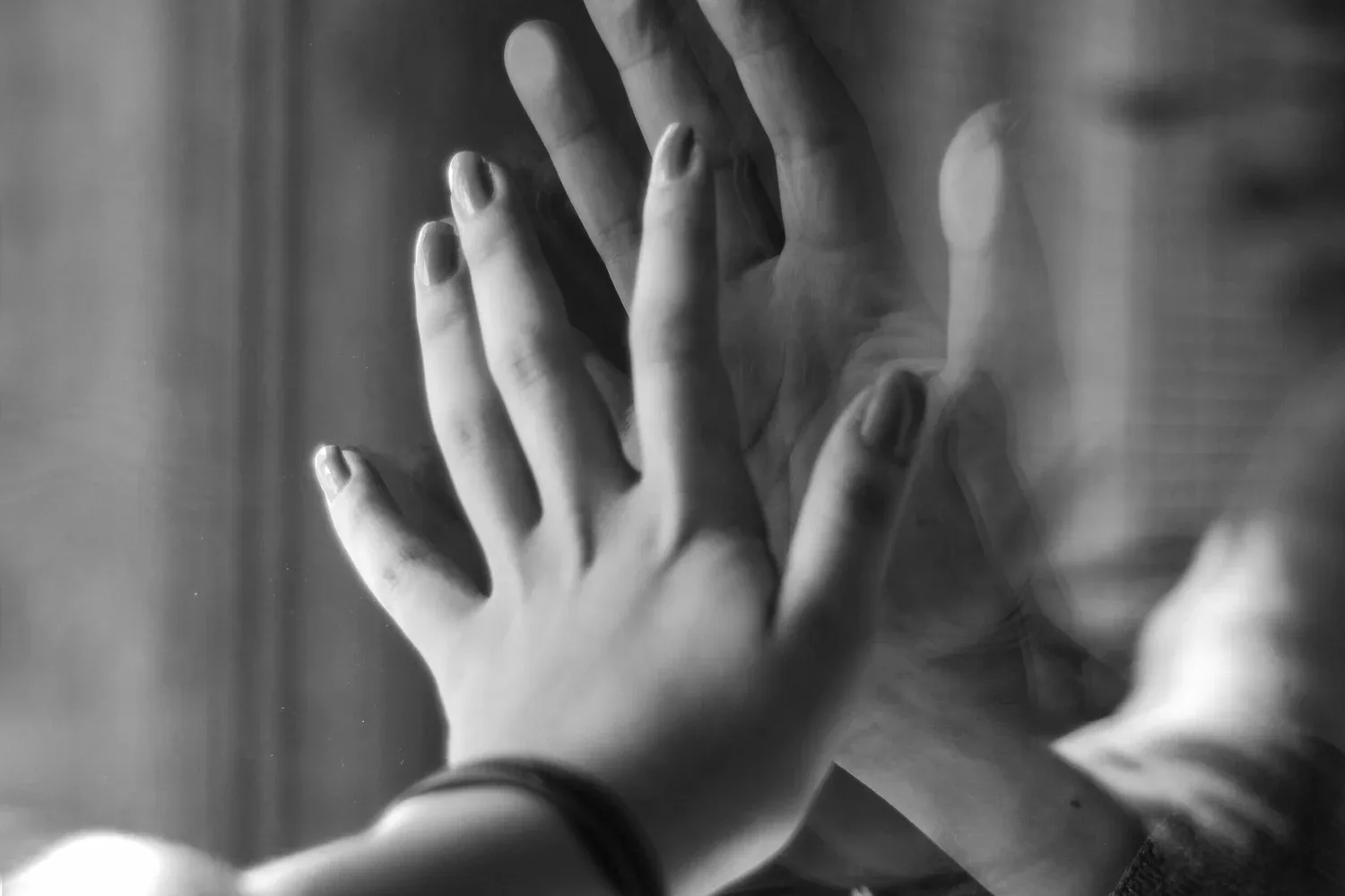 Black-and-white photo of two hands pressed together palm to palm