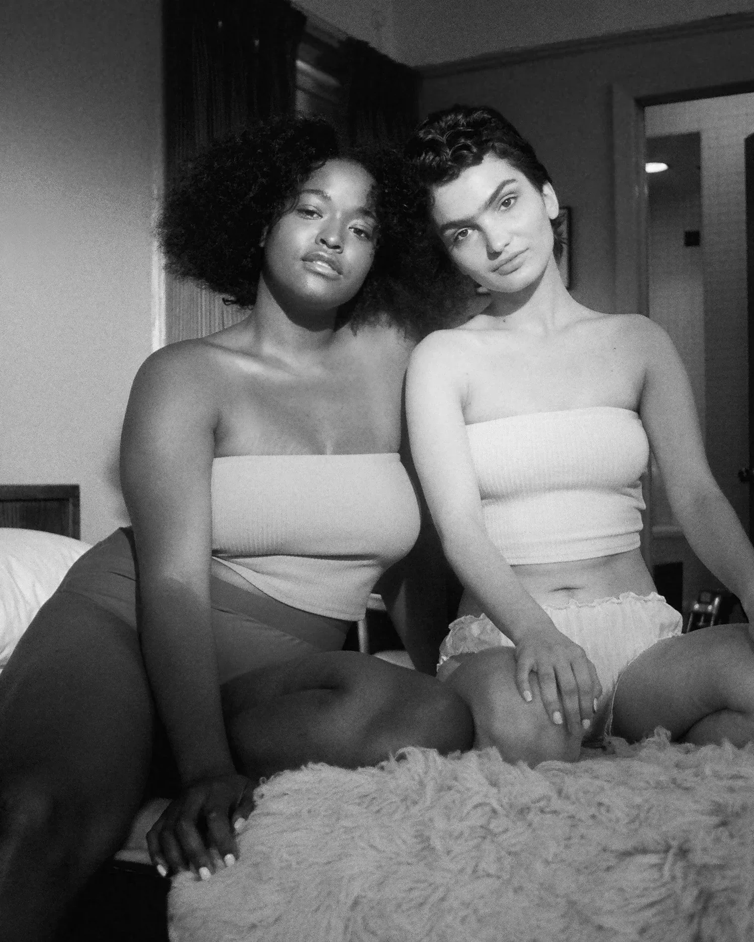 Black-and-white photo of two women with different body types sitting together