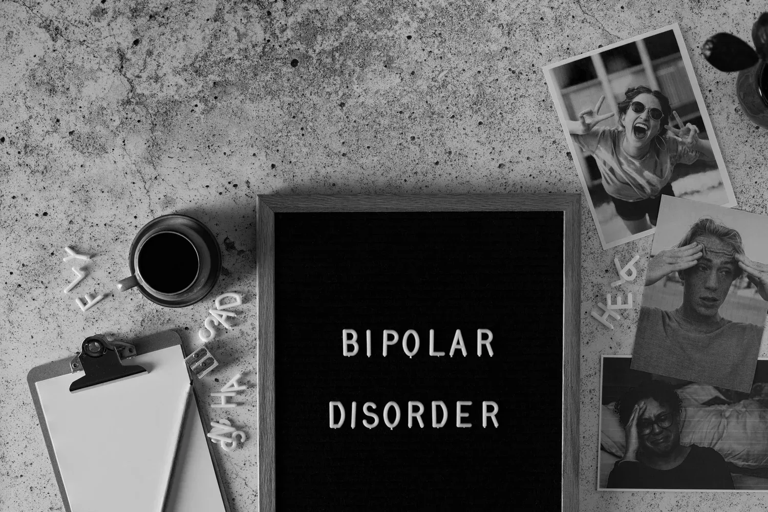 Letter board reading BIPOLAR DISORDER on a desk with papers and a clipboard