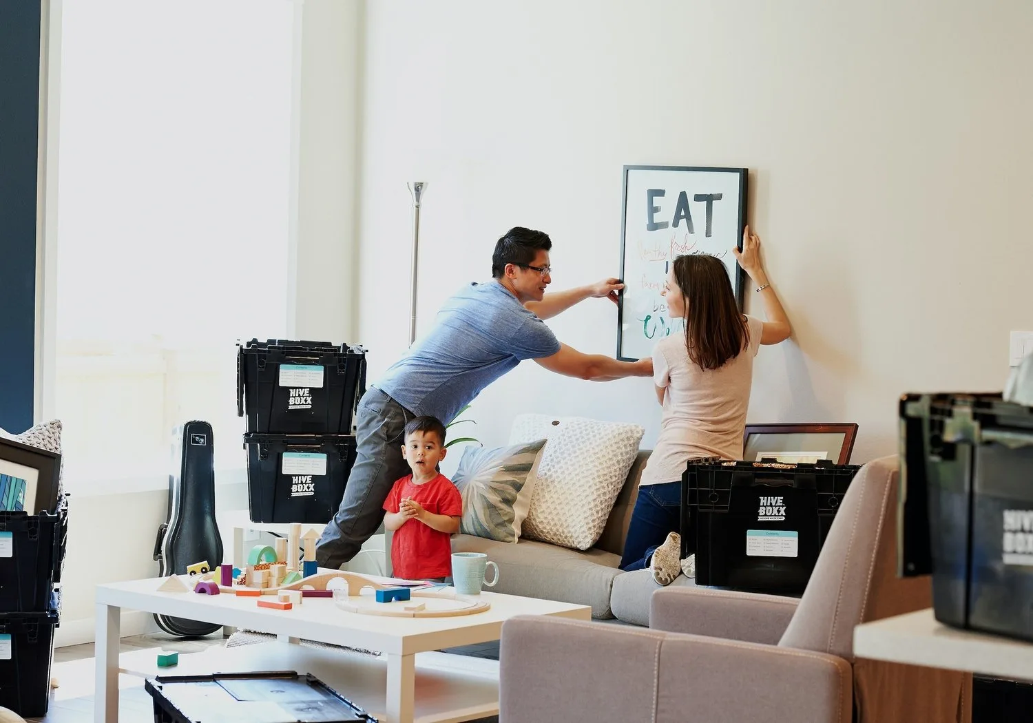 Couple unpacking and hanging a sign in a new apartment