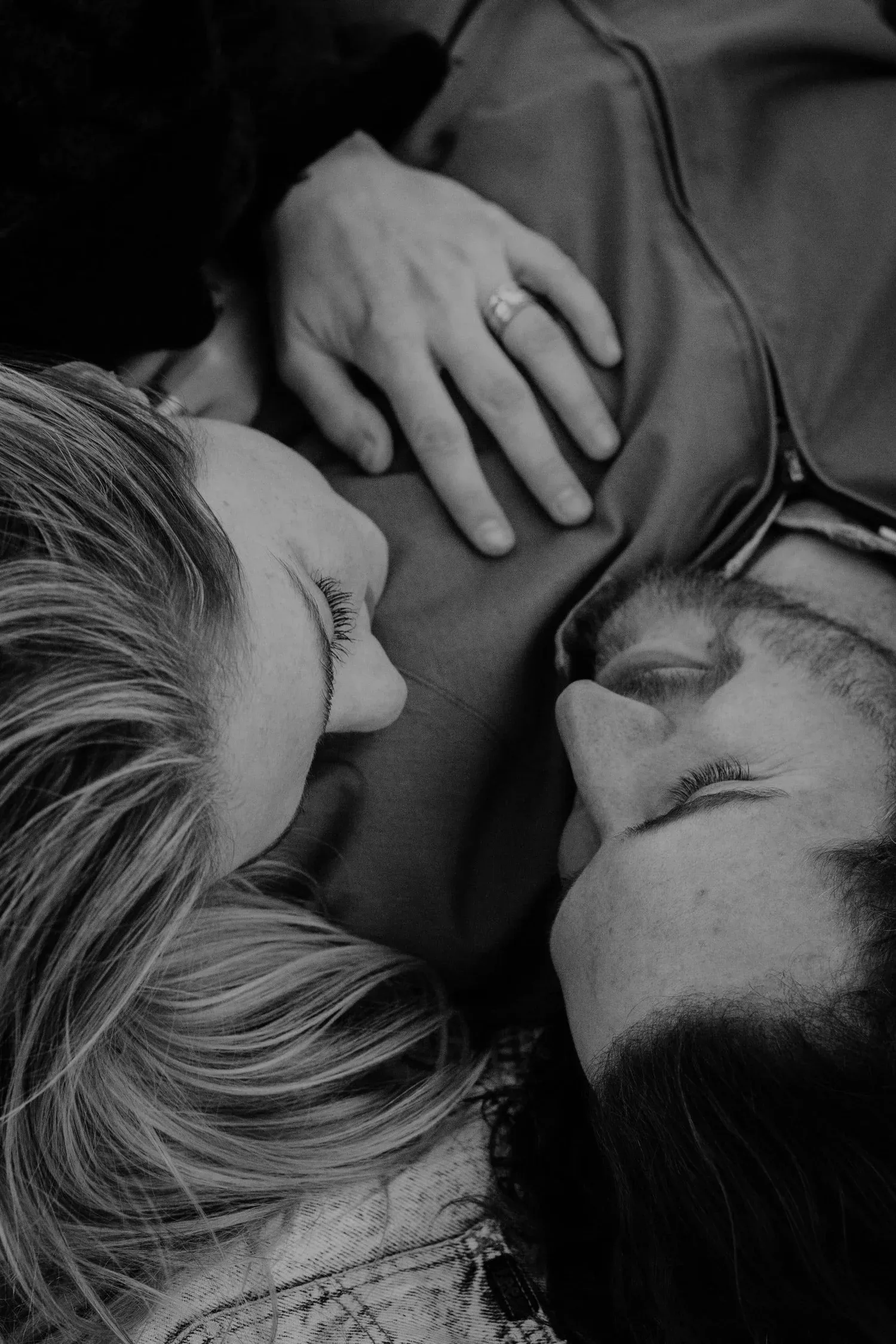 Black-and-white close-up of two people lying close together