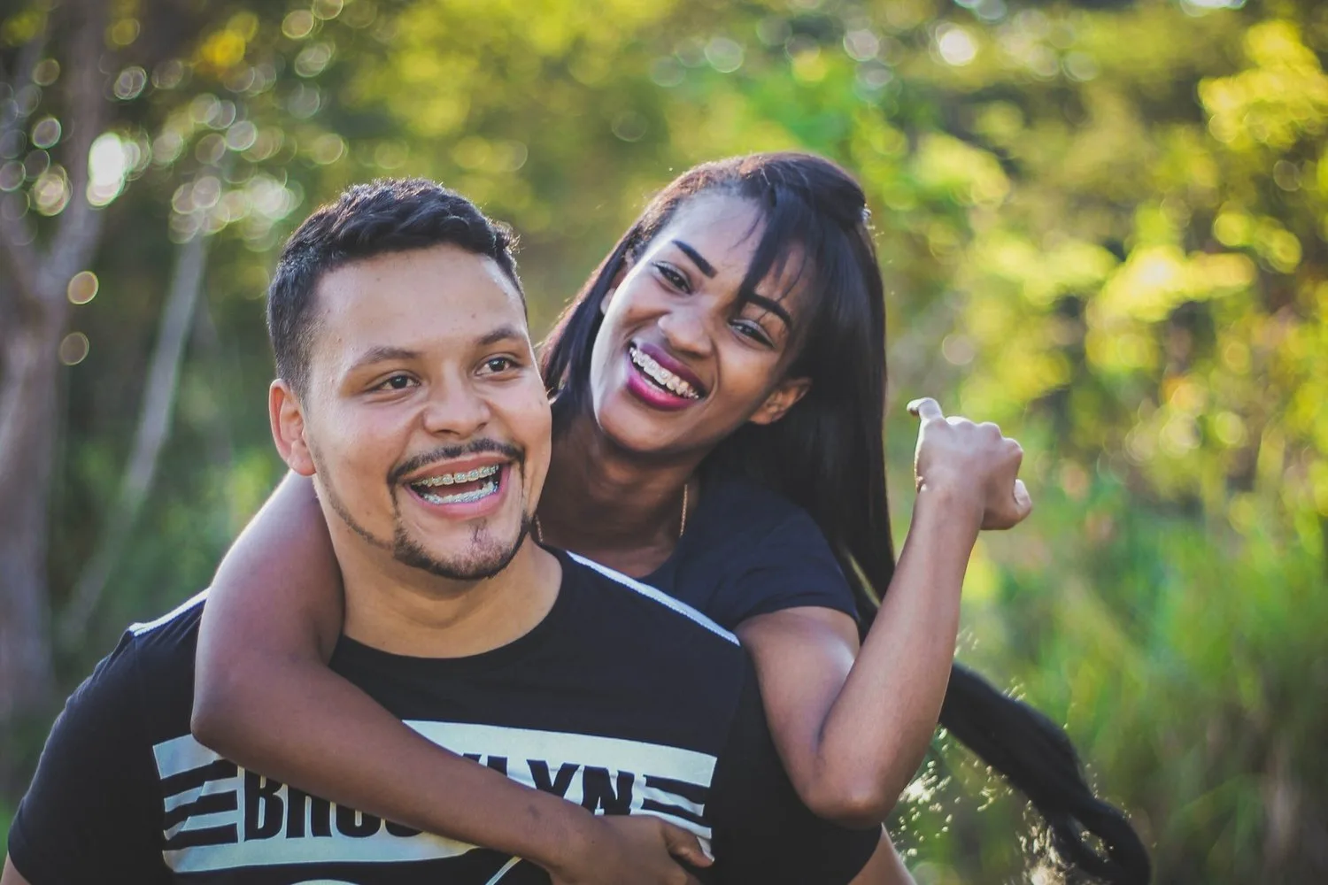 Smiling couple embracing outdoors among greenery