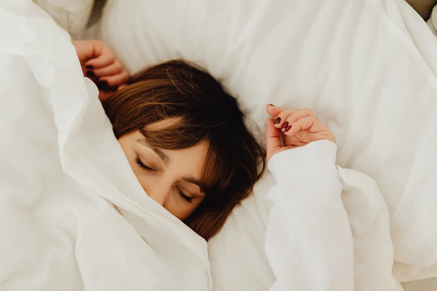 Person asleep, wrapped in a white duvet