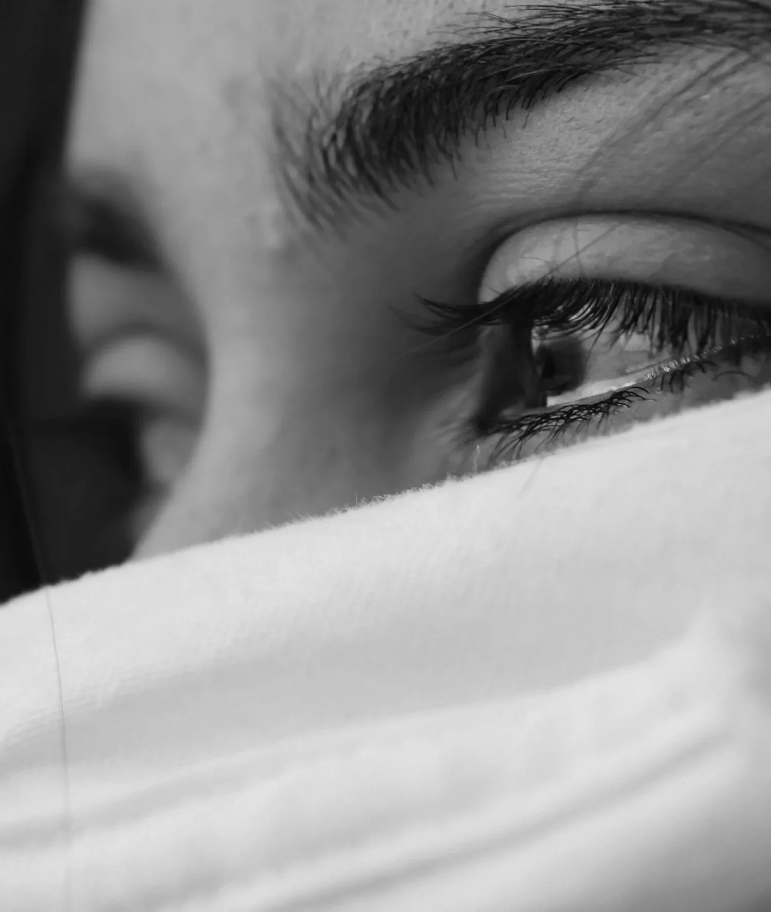 Black-and-white close-up of eyes above a face mask