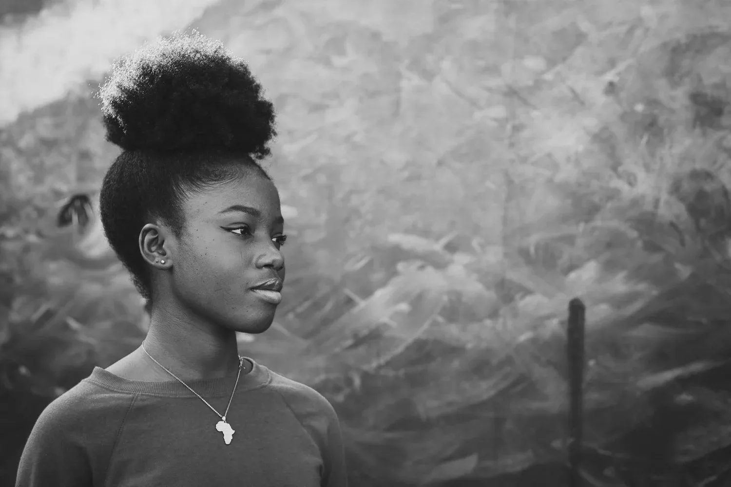 Black-and-white photo of a young woman with her hair in a bun, looking to the side