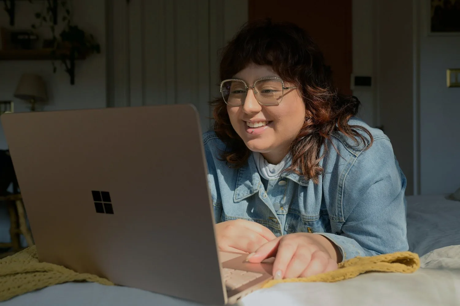 Smiling woman in glasses talking on a video call at her laptop
