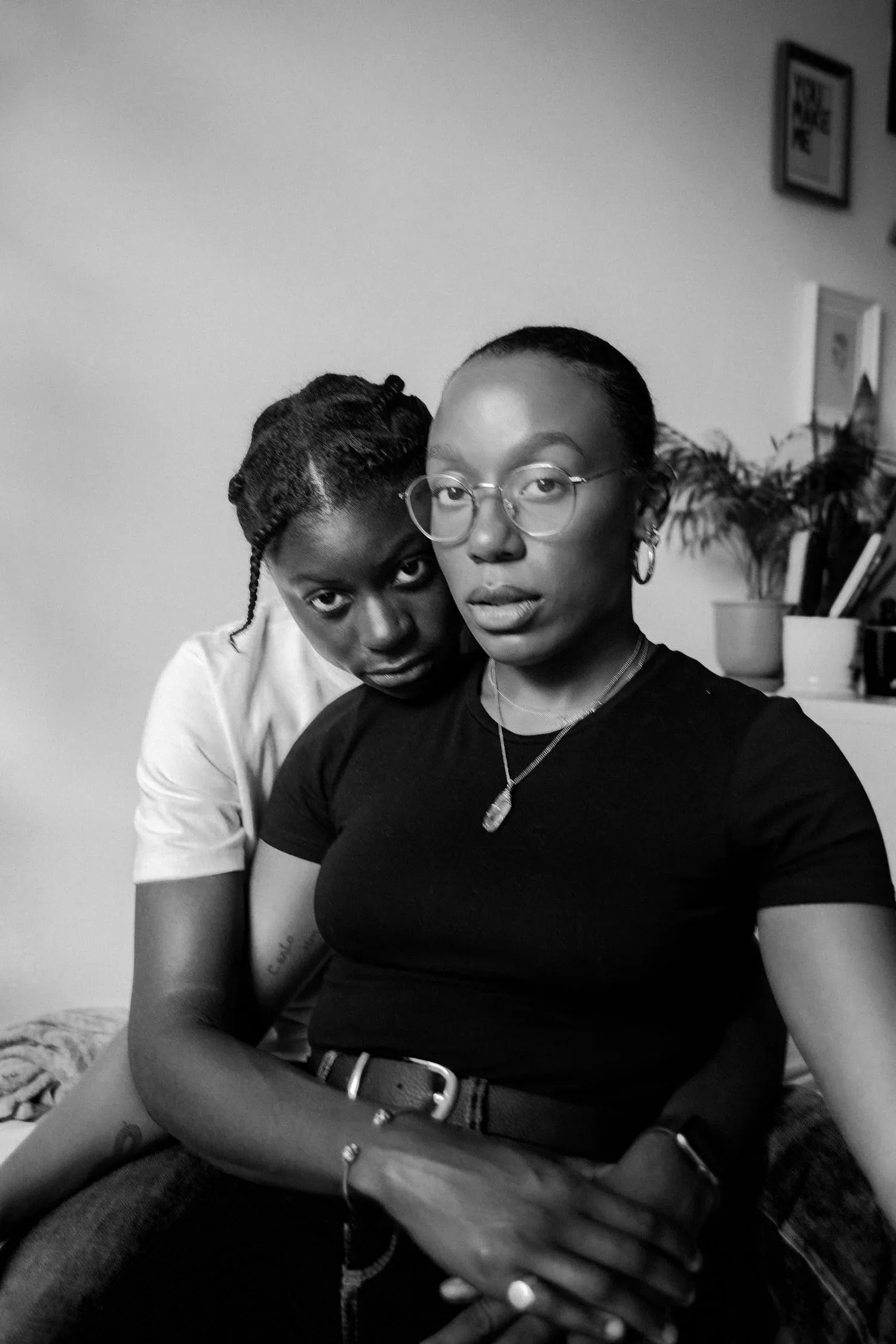 Black-and-white photo of two women sitting close together at home