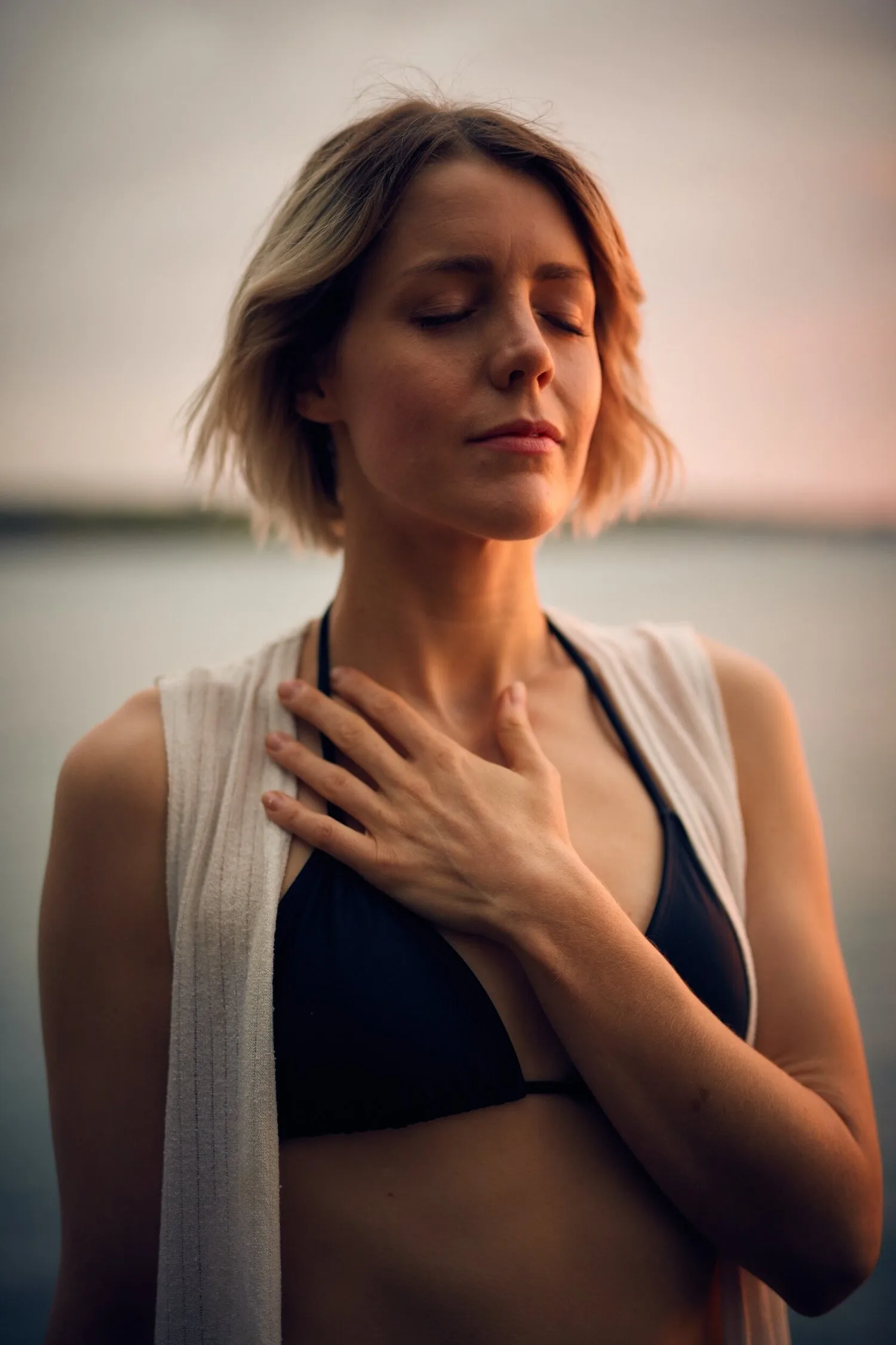 Woman with eyes closed and both hands resting on her chest