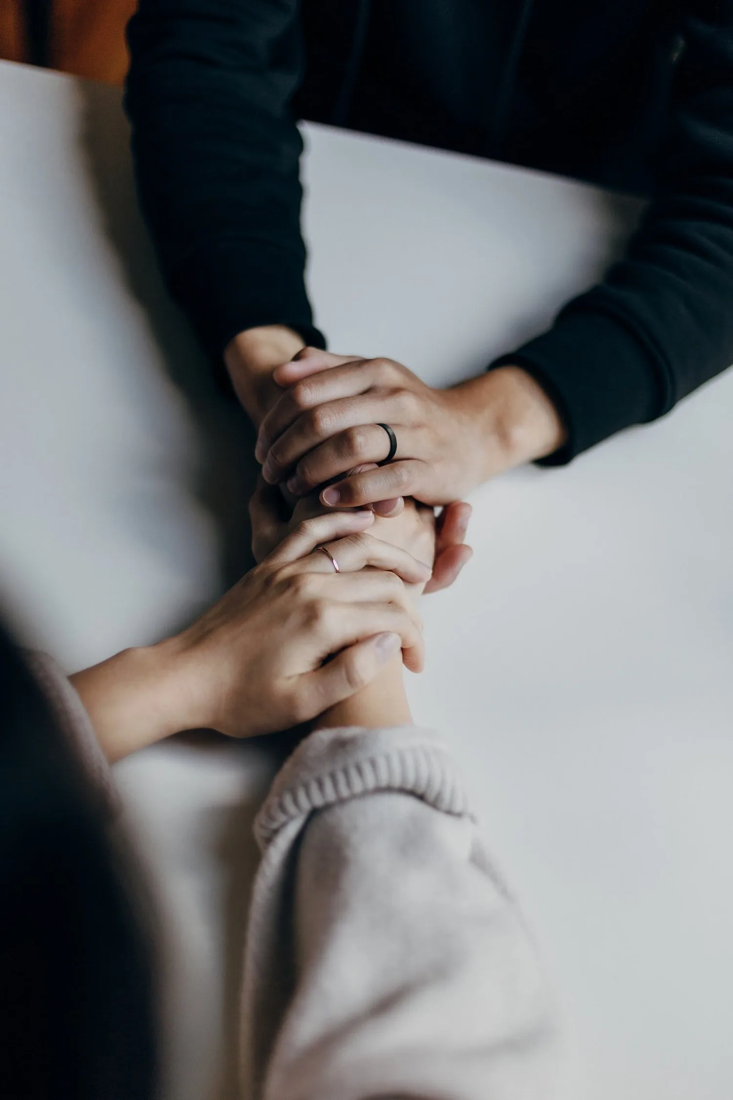 Close-up of two people holding hands in comfort
