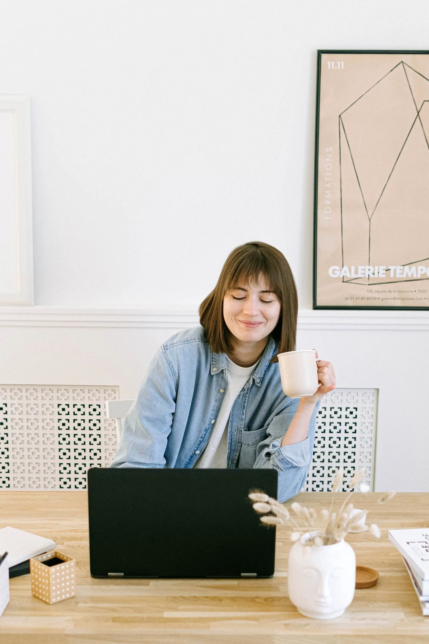 Smiling woman working at a laptop at a wooden table