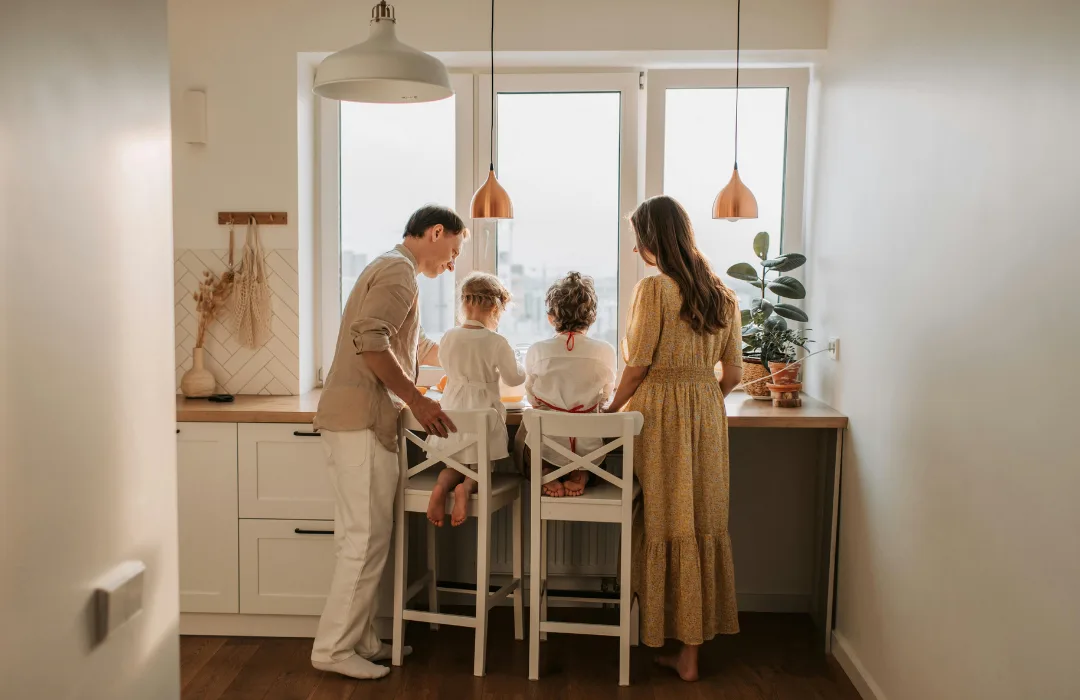 Family gathered at a kitchen counter preparing food together