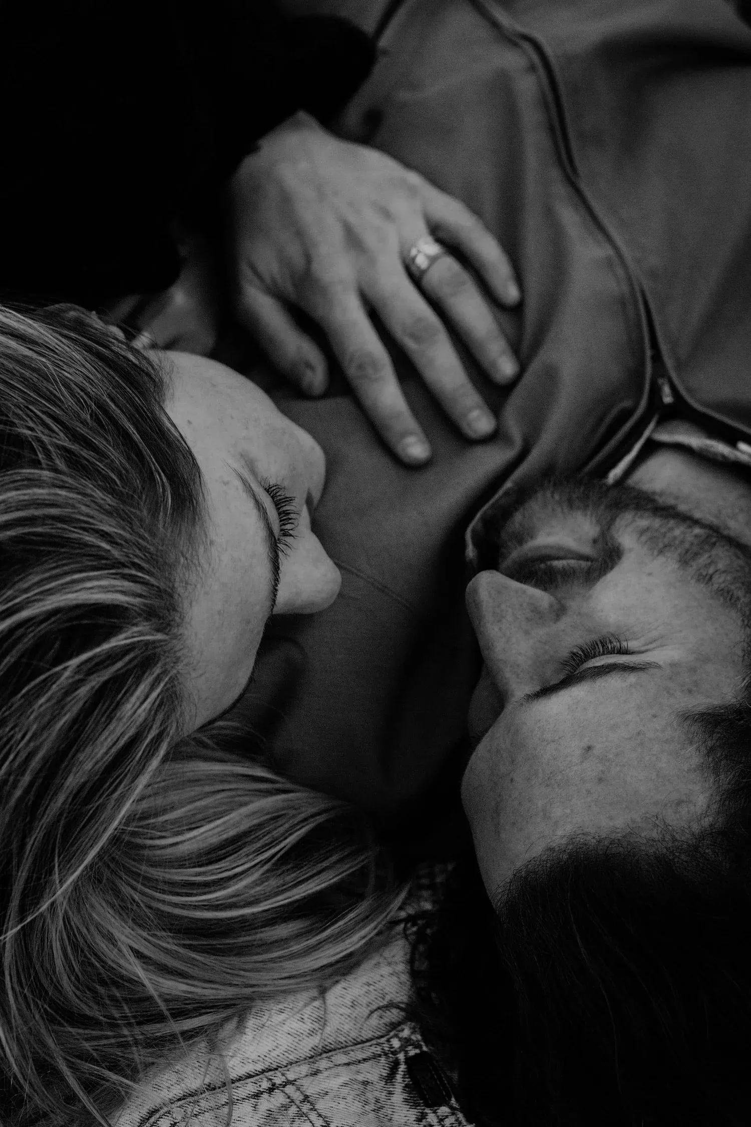 Black-and-white close-up of two people lying close together