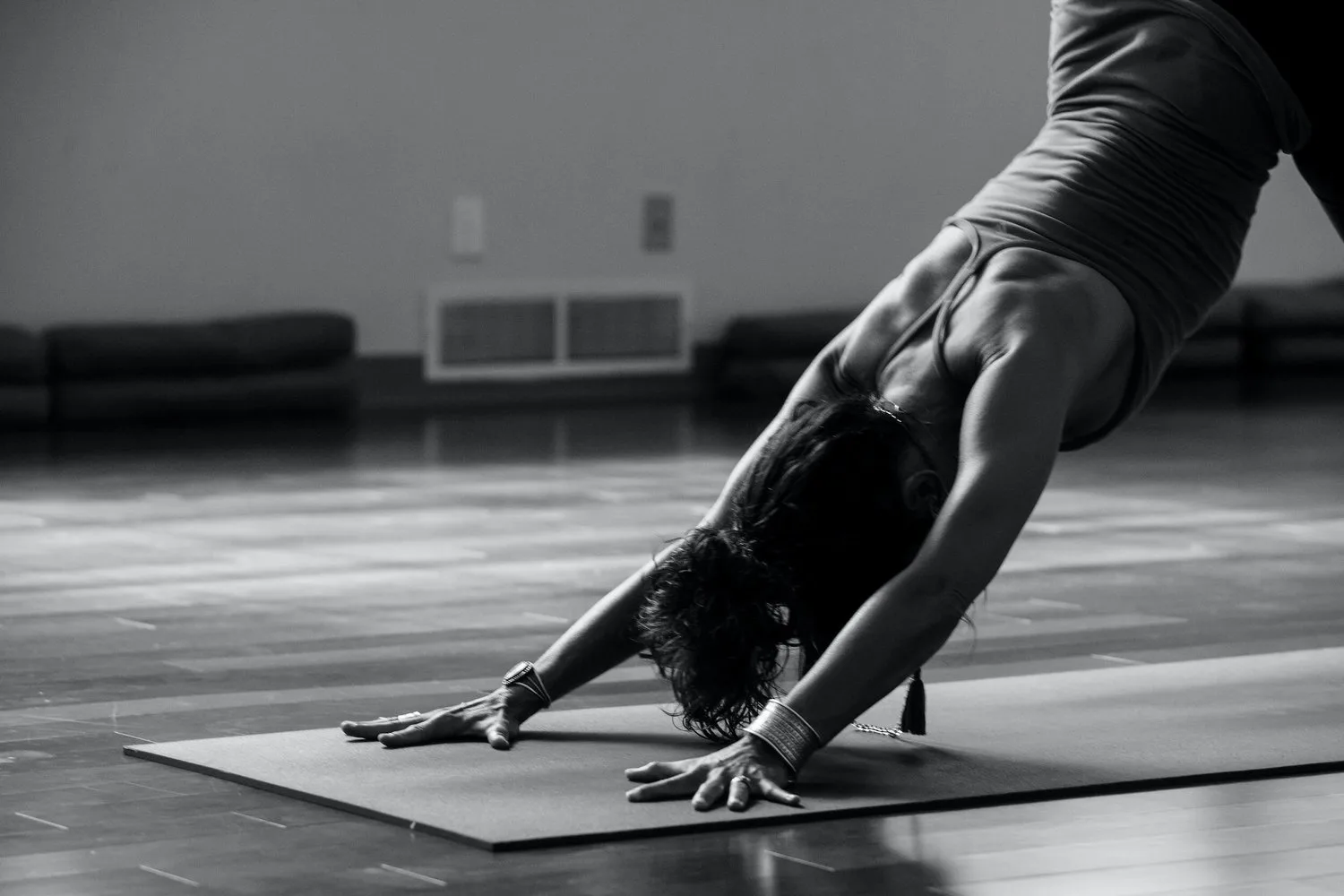 Black-and-white photo of a person in a downward-facing stretch on a mat