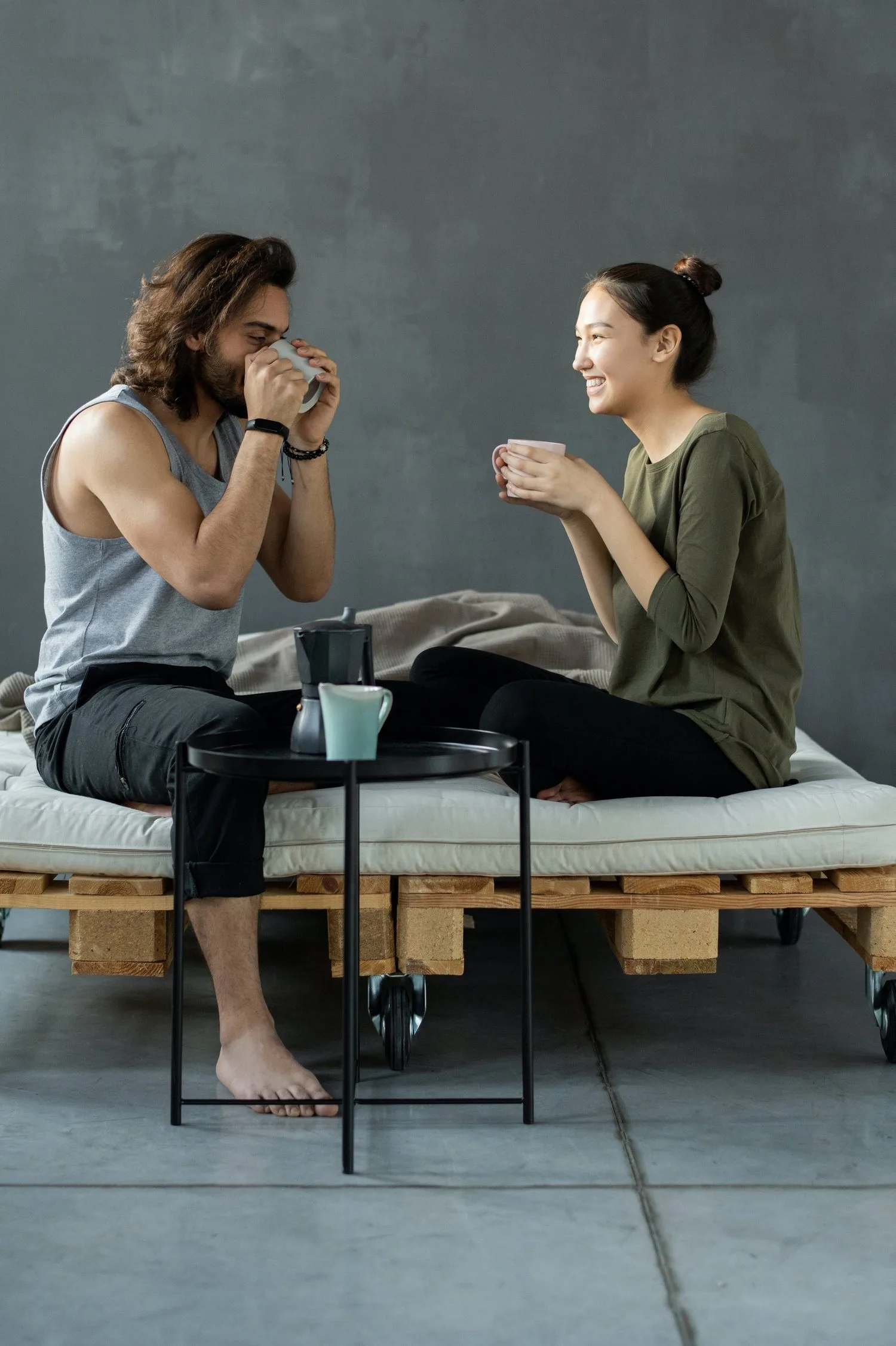 Two women talking over tea on an outdoor bench