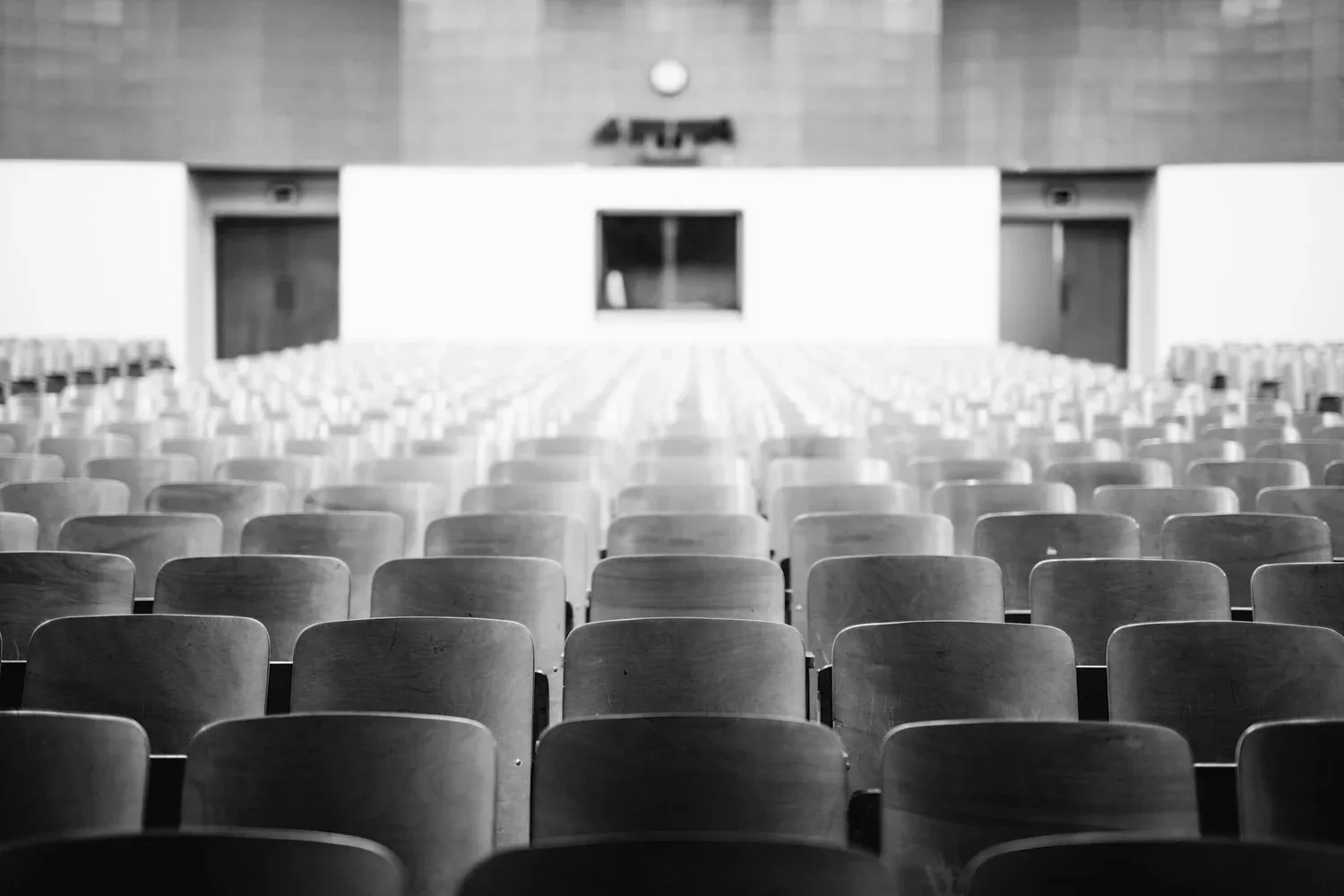 Black-and-white photo of rows of empty auditorium seats