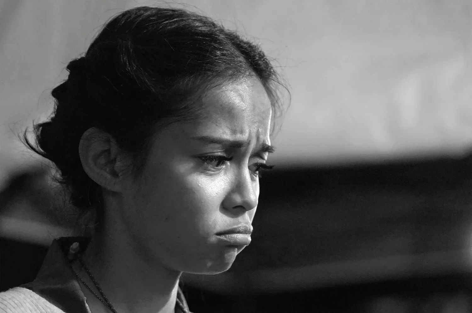 Black-and-white close-up of a young woman looking upset