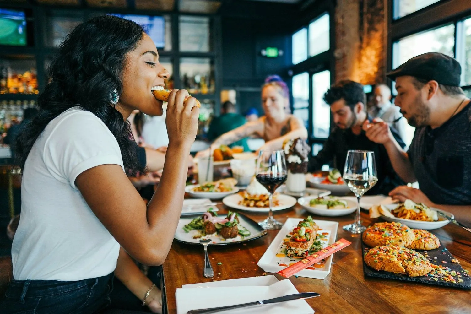 Friends eating a shared meal at a busy restaurant table