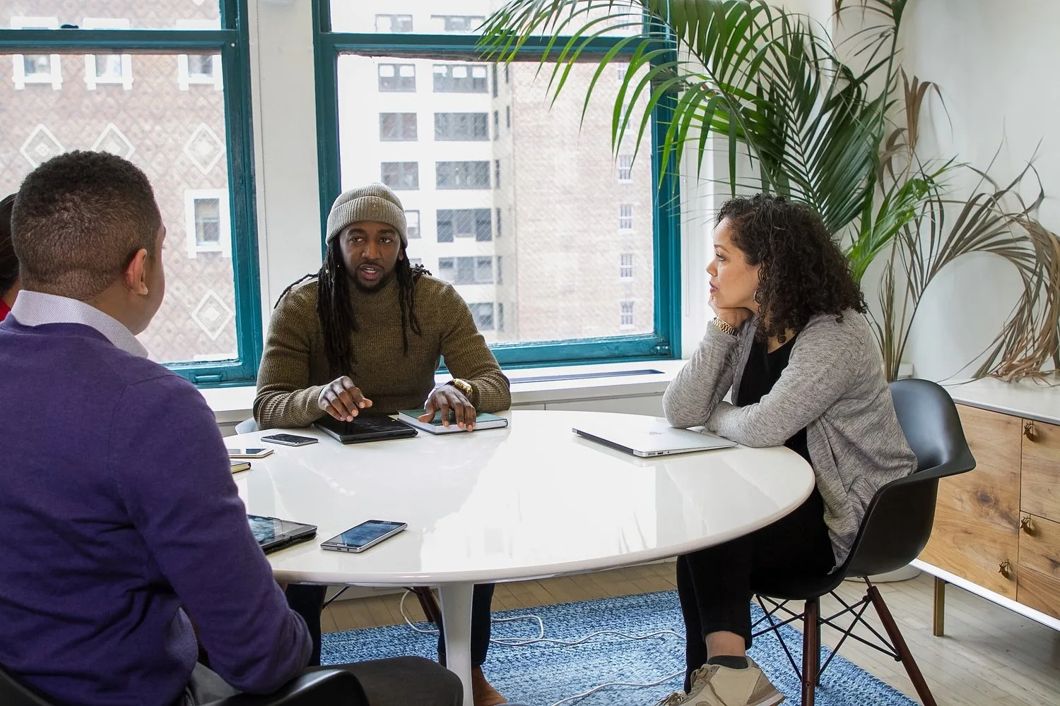Small group meeting around a table in a bright office