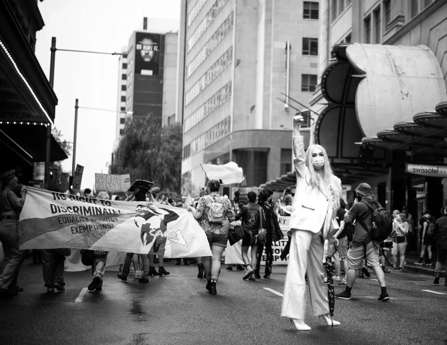 Black-and-white photo of a crowded city street during a march