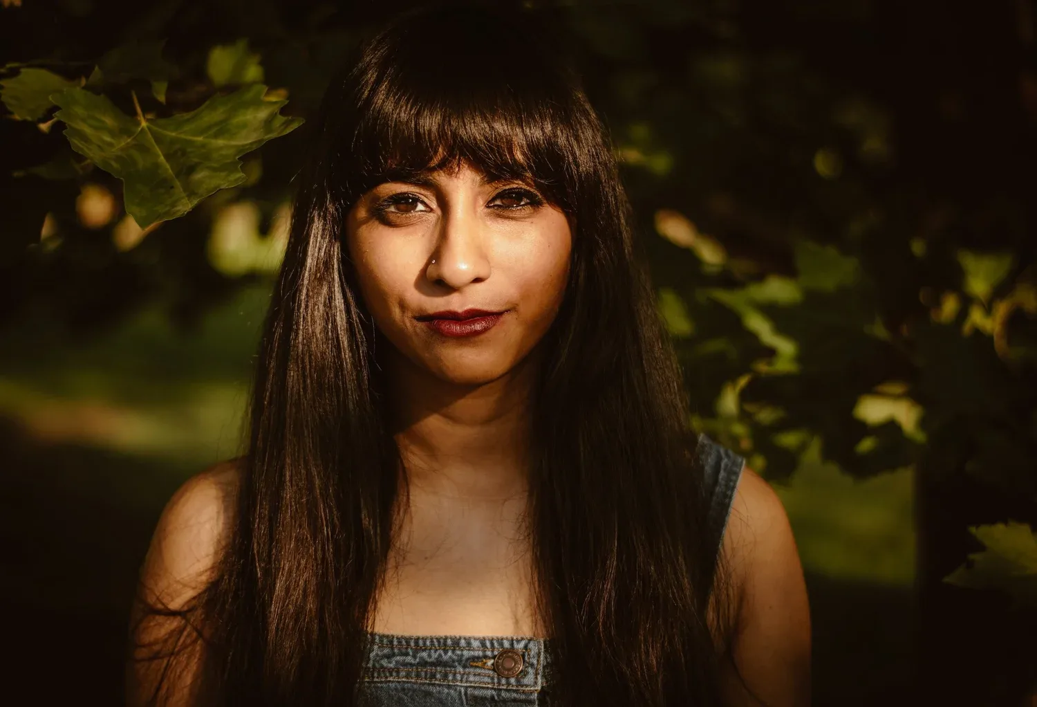 Portrait of a young woman with bangs among greenery