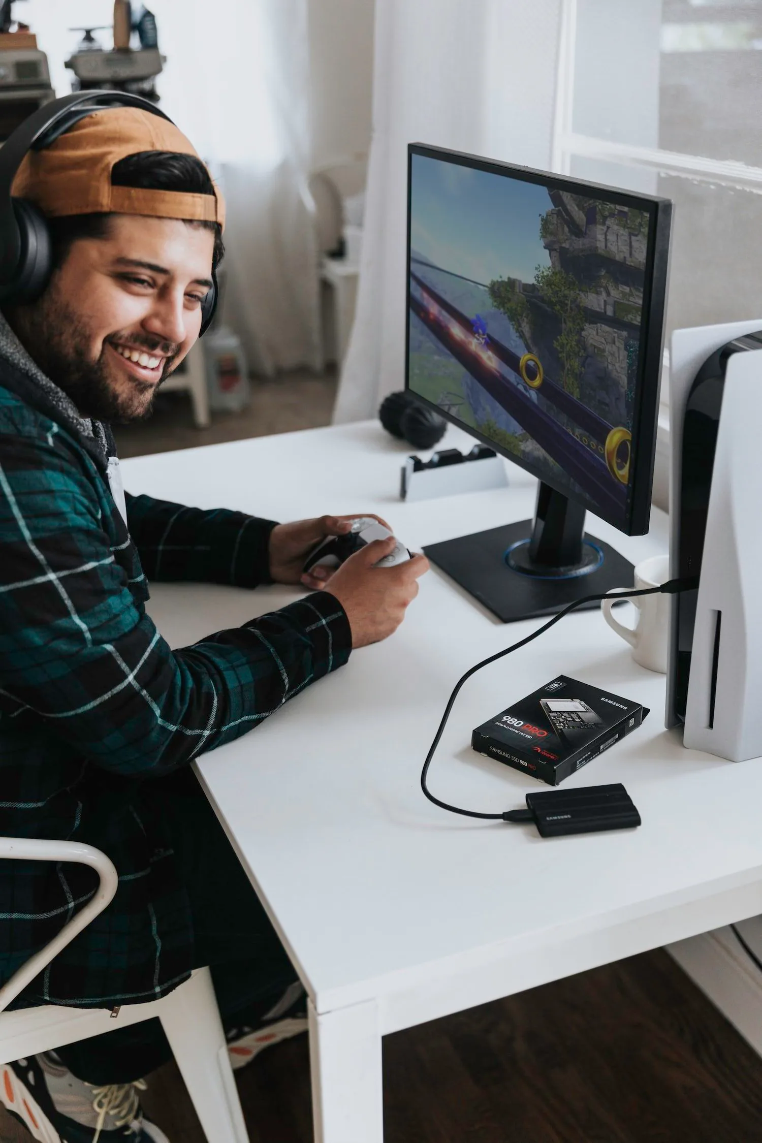 Smiling man in headphones working at a computer desk