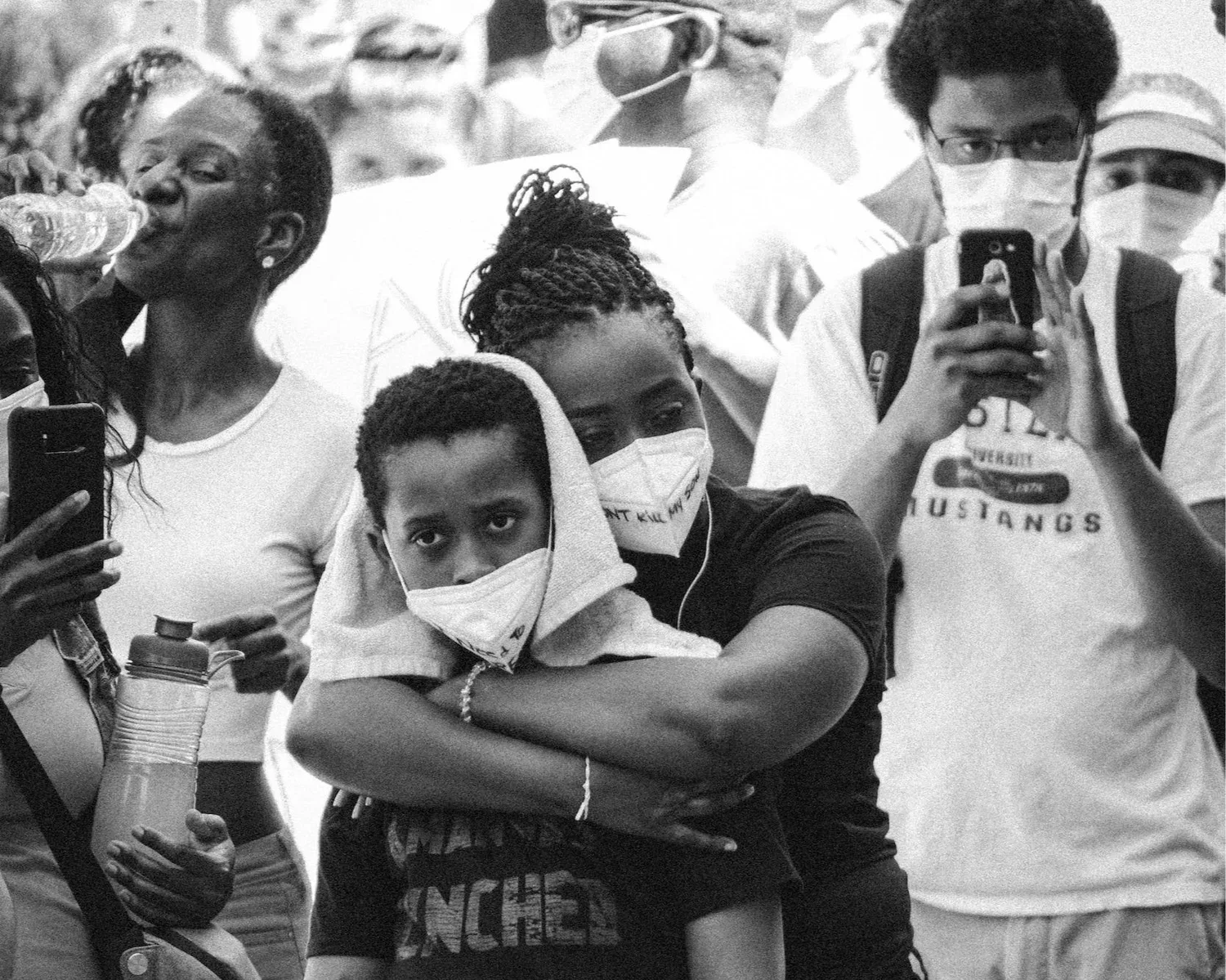 Black-and-white photo of protesters in face masks at a demonstration