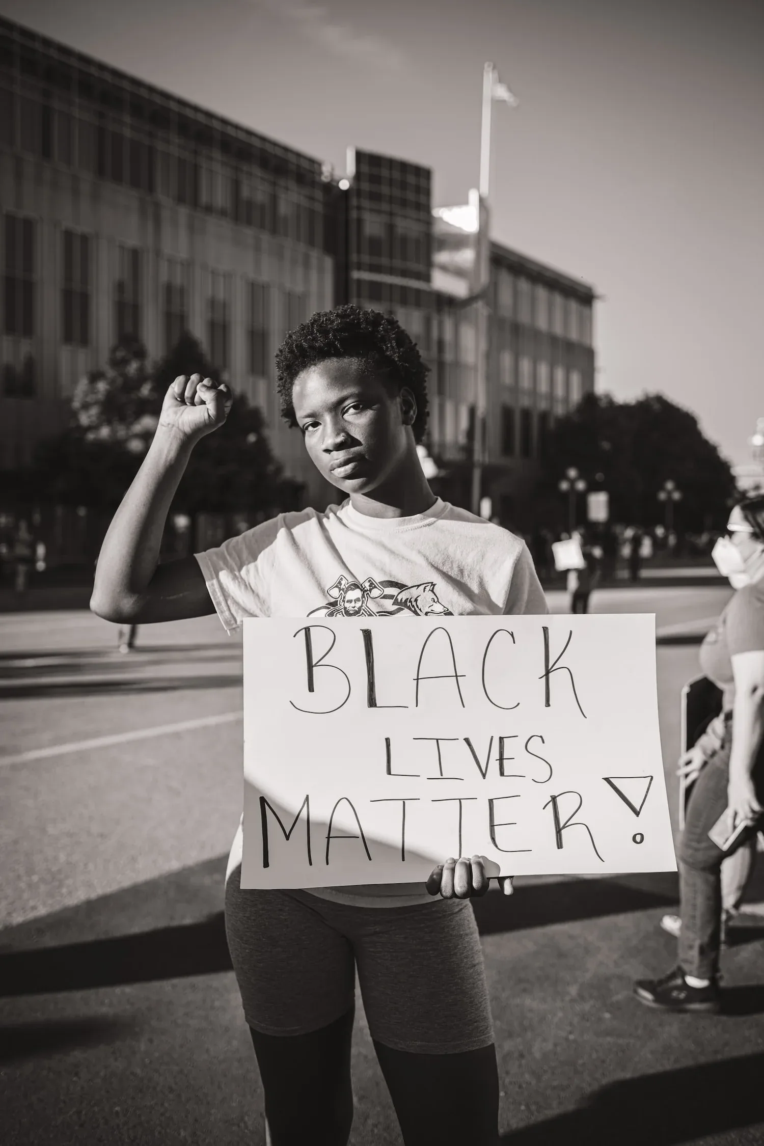 Black-and-white photo of a protester holding a Black Lives Matter sign