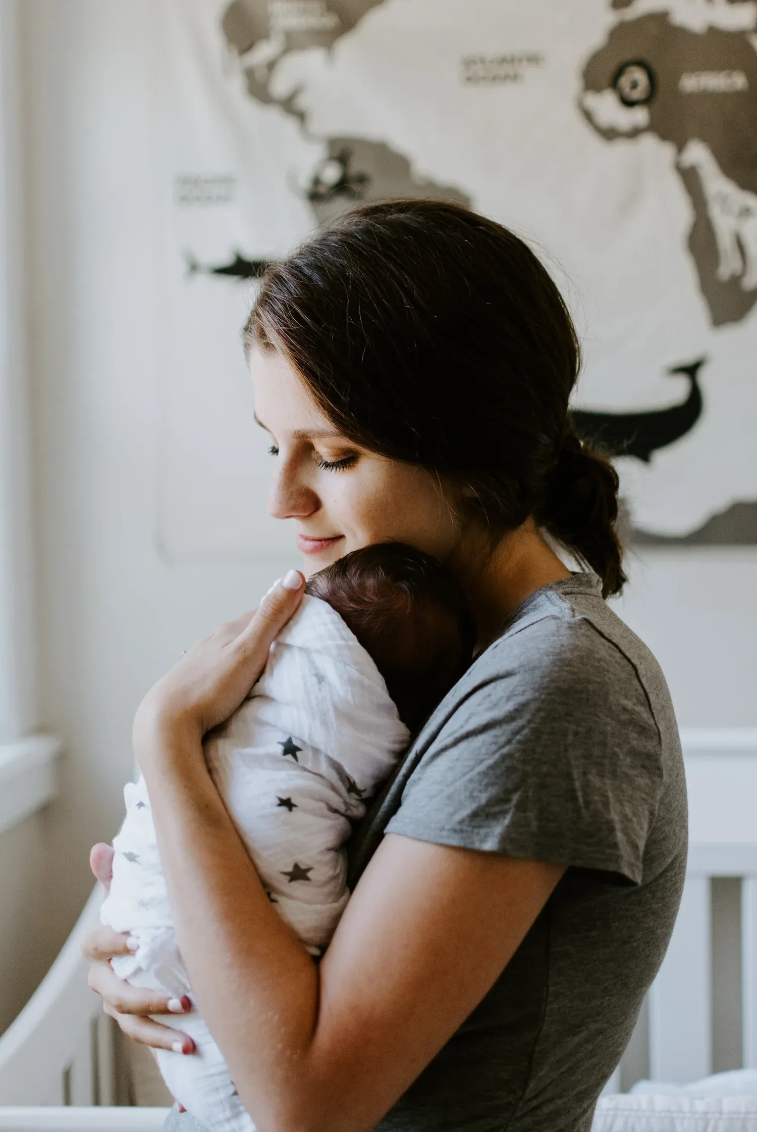 Woman gently holding a sleeping newborn against her chest