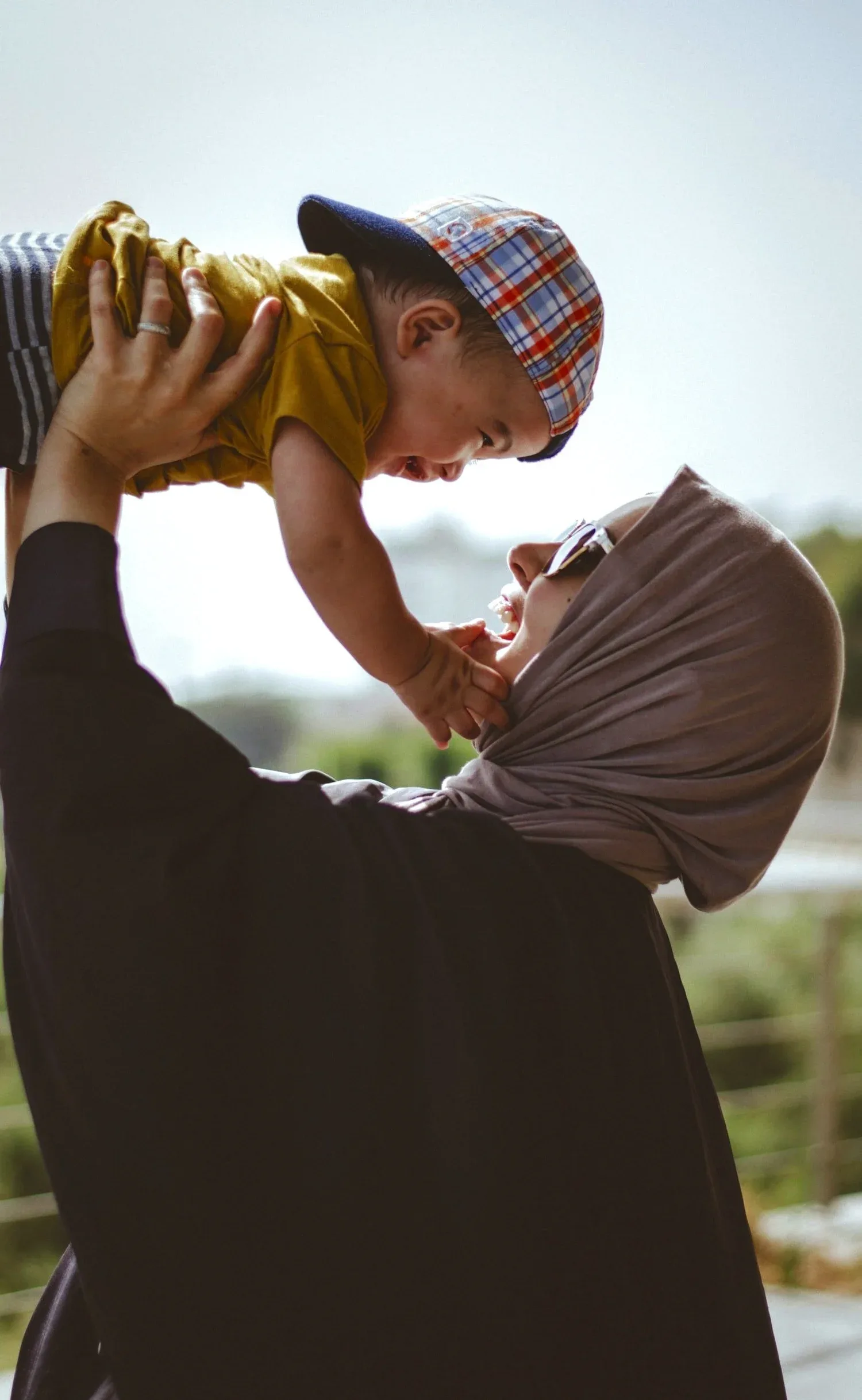 Parent lifting a laughing toddler into the air
