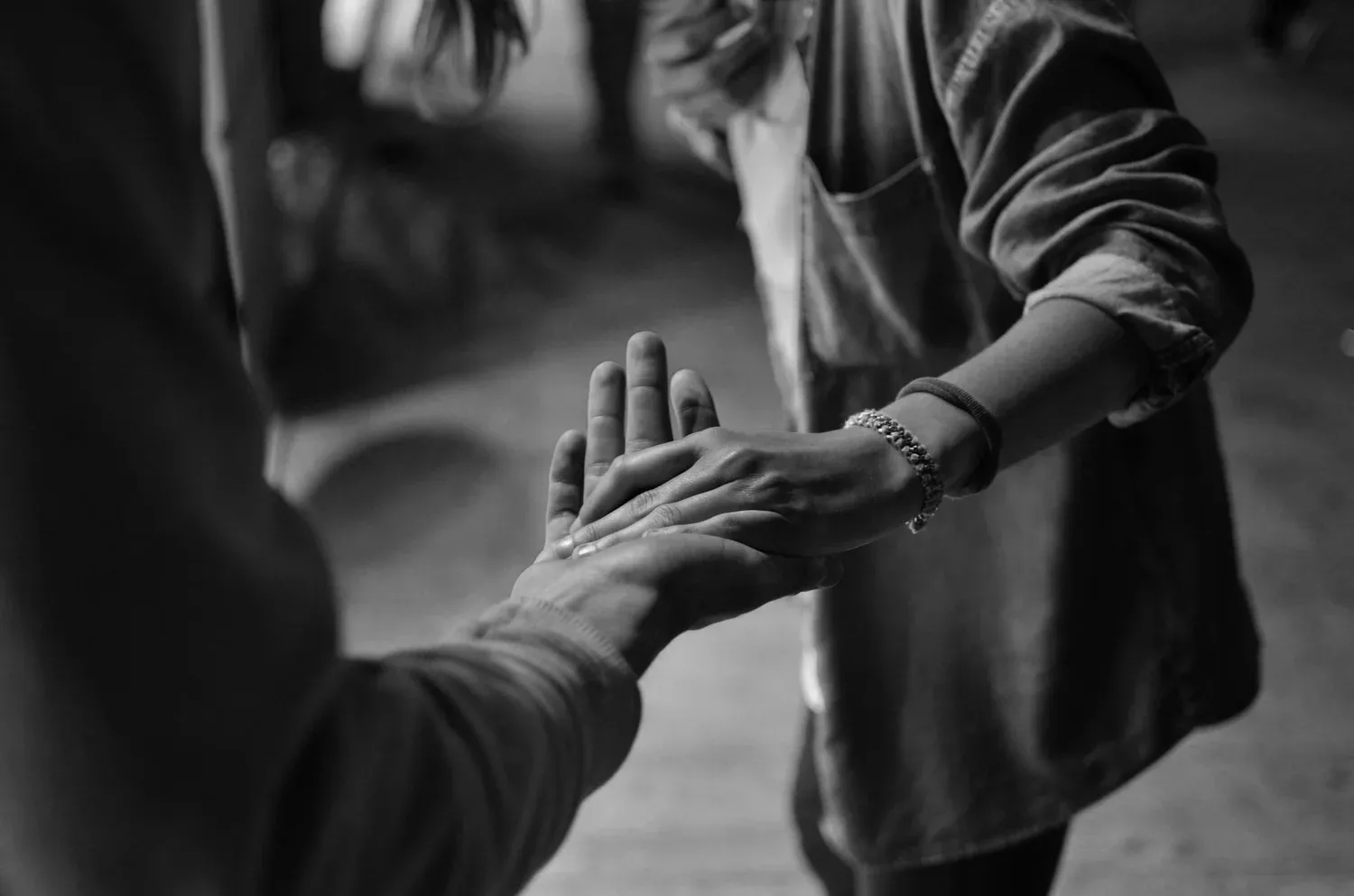 Black-and-white photo of two hands touching palm to palm