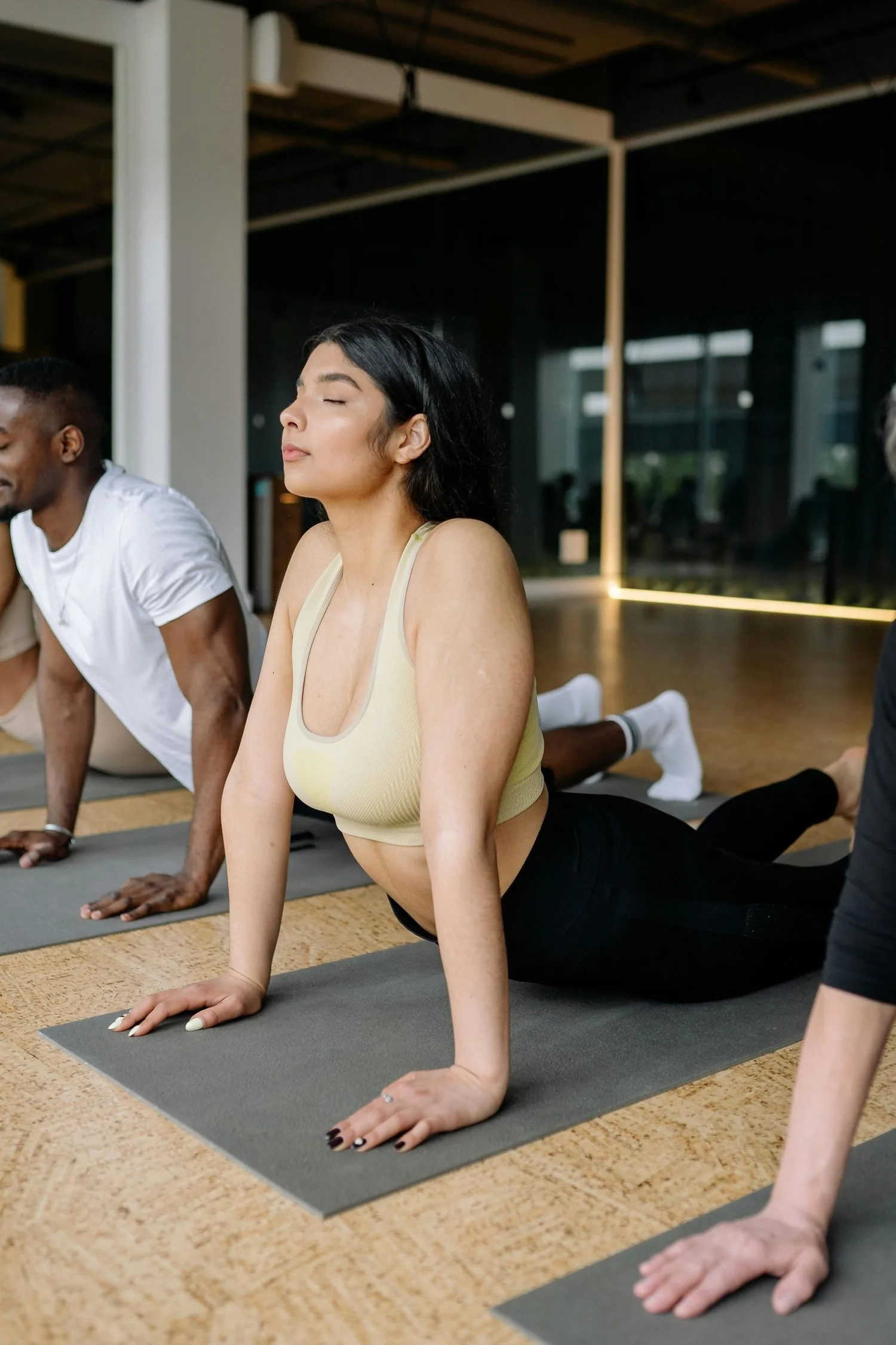 Woman in a gentle backbend stretch on a mat during a group movement session