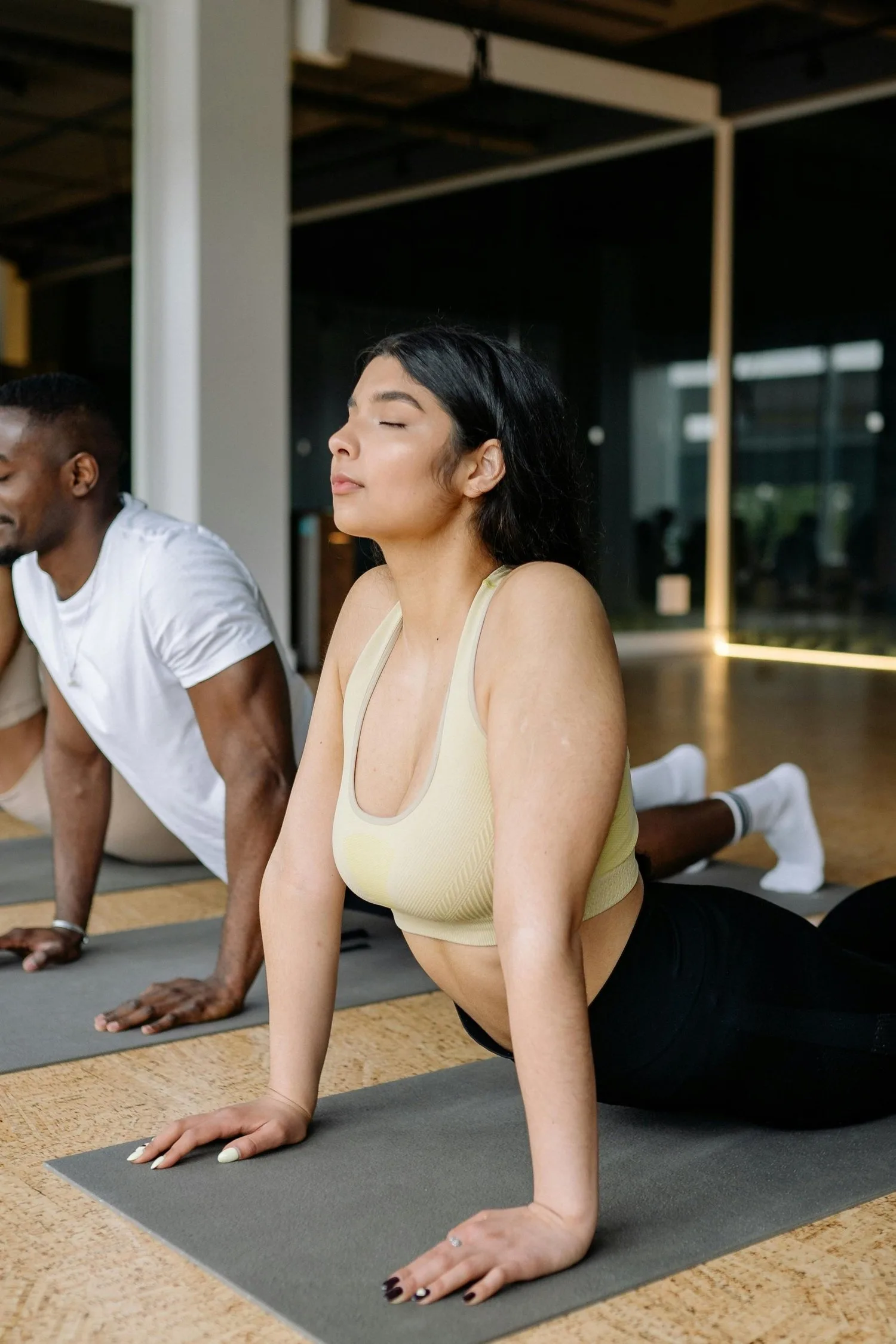 Woman in a gentle backbend stretch on a mat during a group movement session