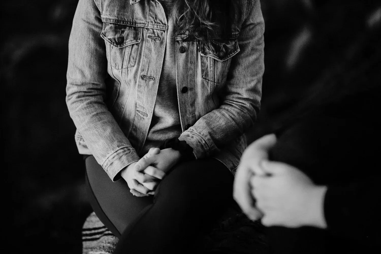 Two people seated side by side with hands clasped in their laps