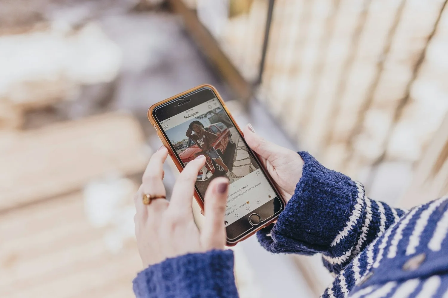 Hands holding a phone scrolling through photos