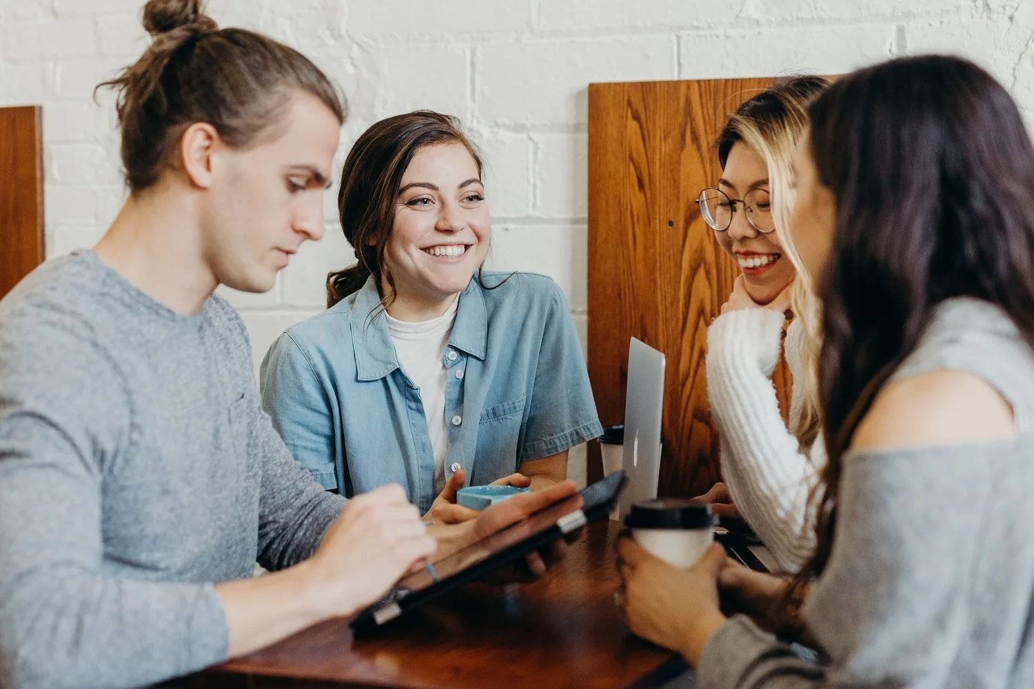 Group of young friends chatting and laughing around a table