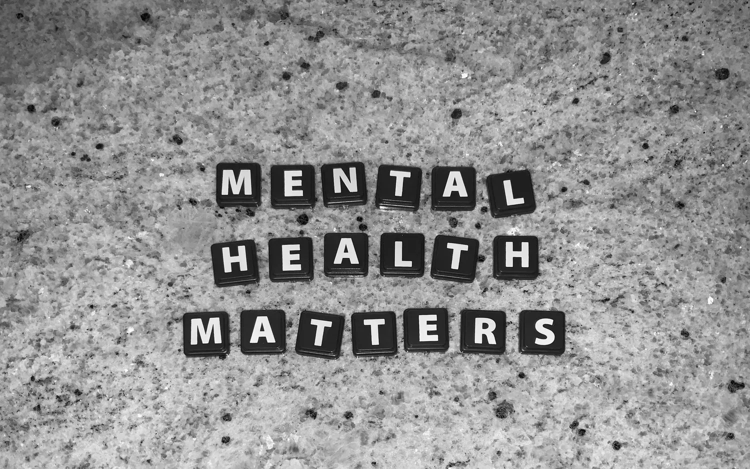 Letter tiles spelling MENTAL HEALTH MATTERS on a textured surface