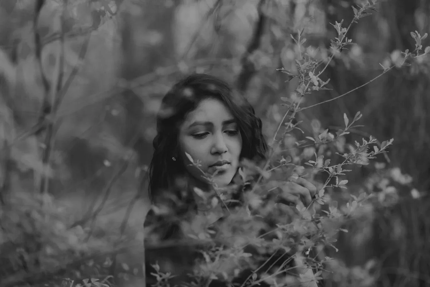 Black-and-white photo of a woman surrounded by wild plants