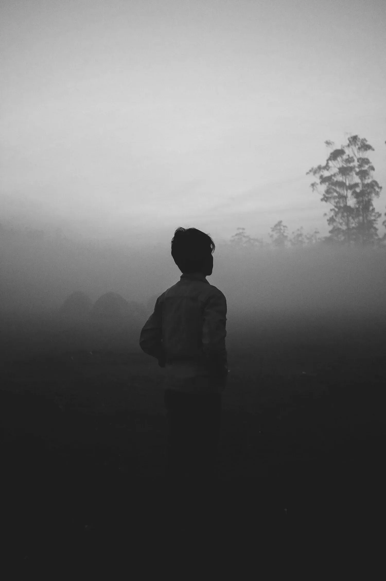 Black-and-white photo of a person standing in thick fog