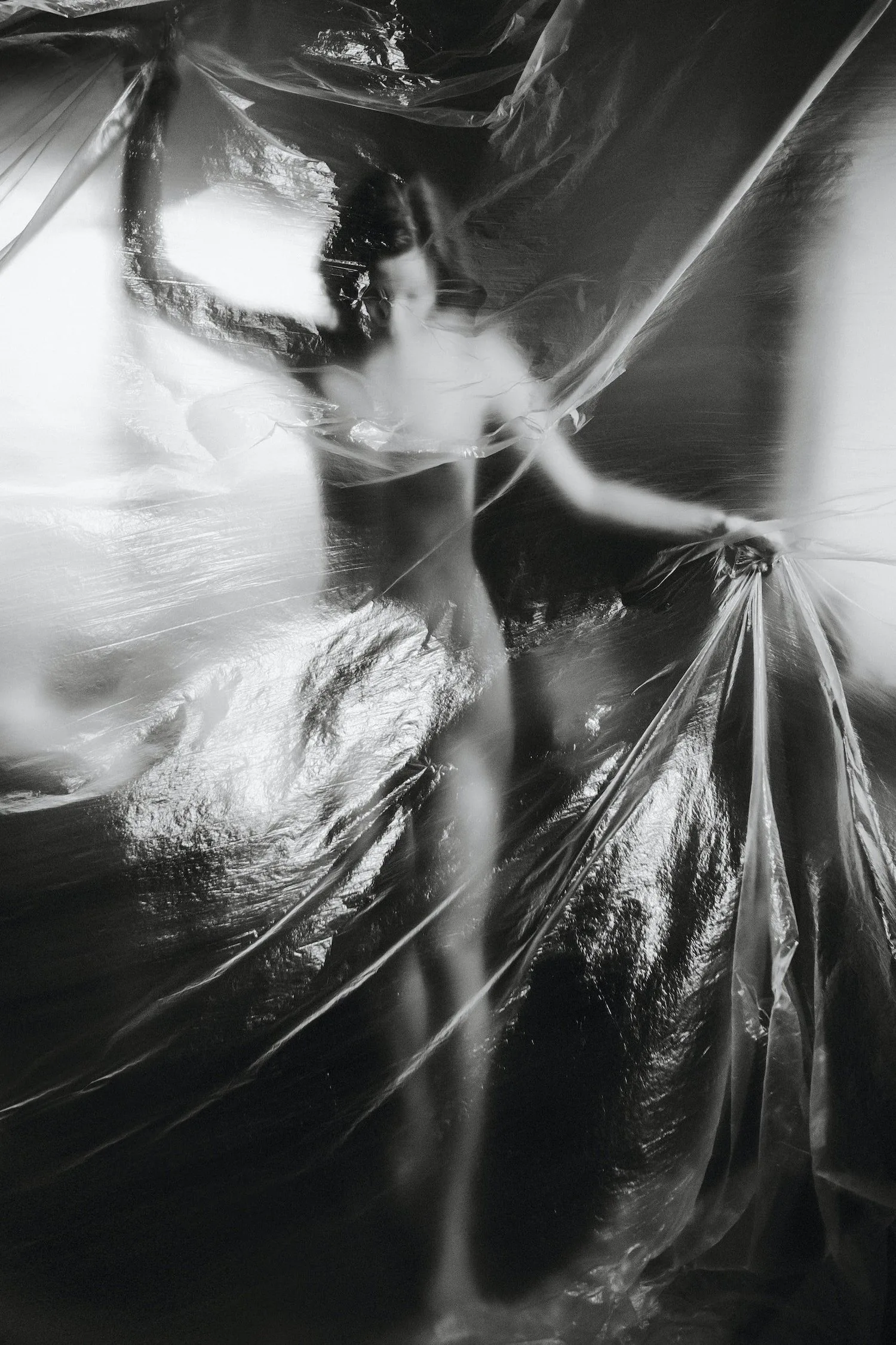 Black-and-white photo of a dancer mid-movement in flowing fabric