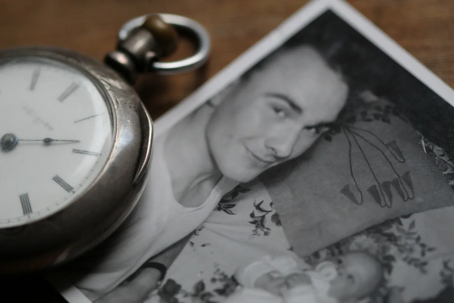 Pocket watch resting on old photographs