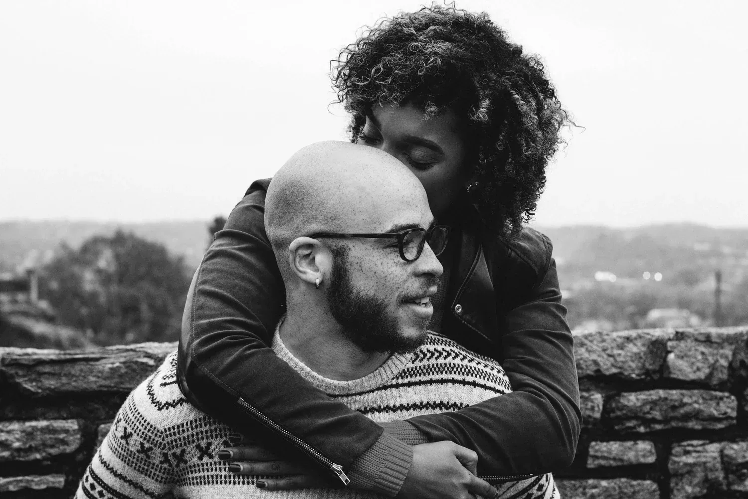 Black-and-white photo of a smiling couple embracing outdoors