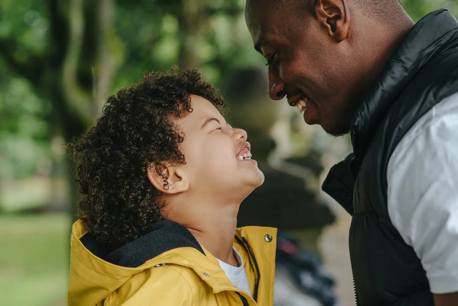 Father and young son sharing a smile outdoors