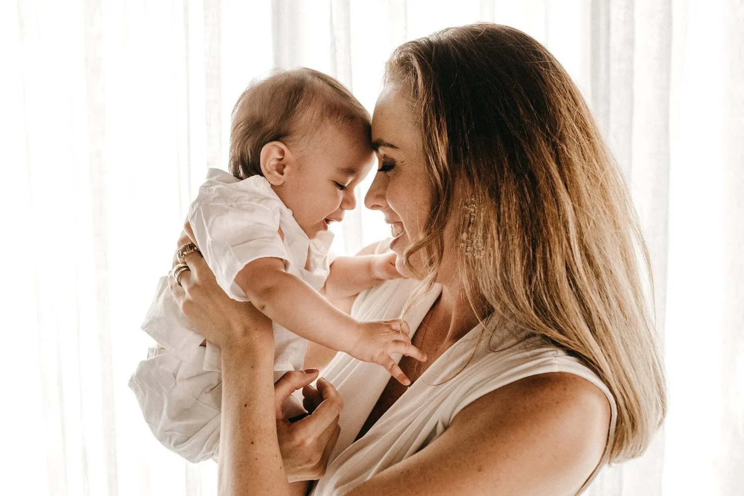 Mother nuzzling her smiling baby close