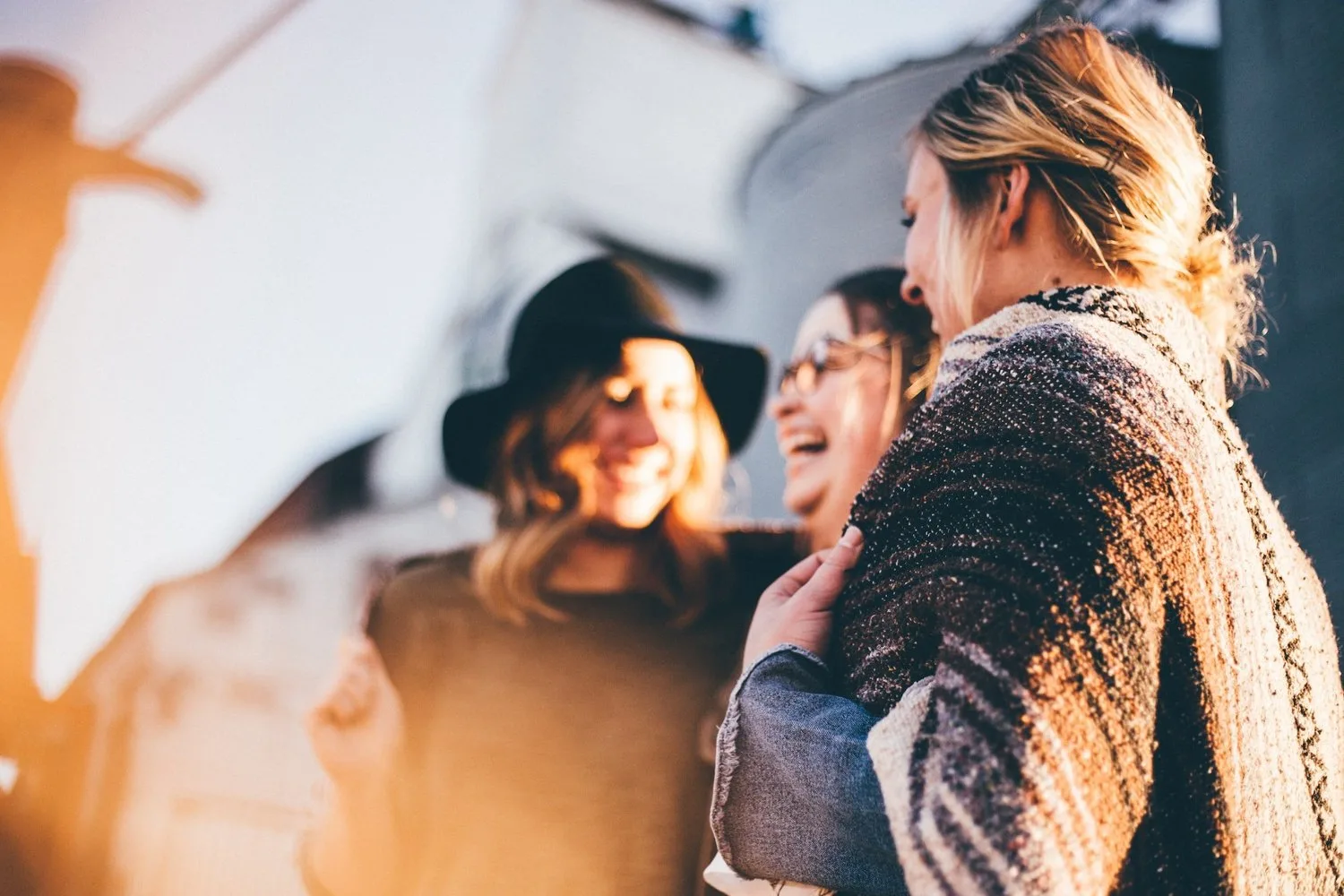 Group of young women laughing together outdoors in the sun
