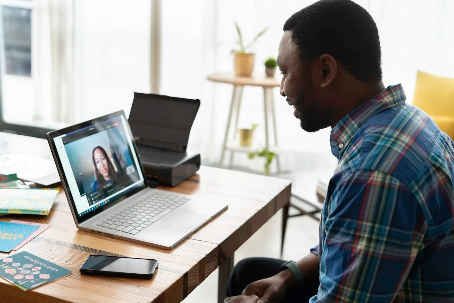 Man on a video call at a laptop with a woman shown on screen
